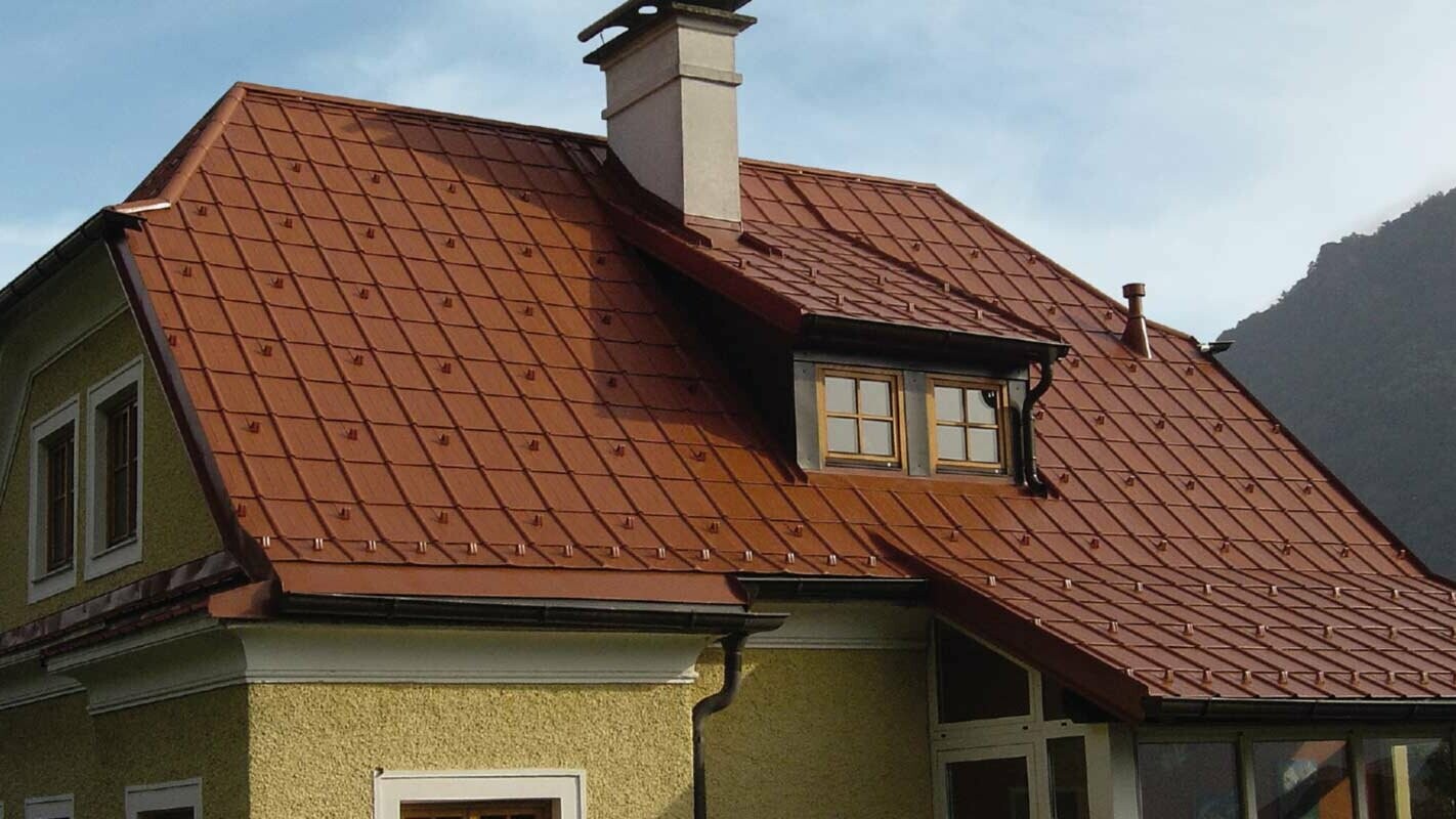 Enodružinska hiša s čopasto streho in mansardnim oknom z novo sanirano streho s strešnimi ploščami PREFA v opečnato rdeči barvi