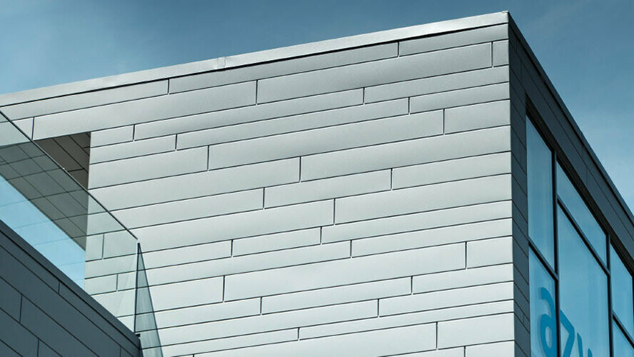 Pri tej zunanji fasadi so bile kombinirane različne dolžine in širine elementov PREFA Siding v P.10 svetlo sivi.