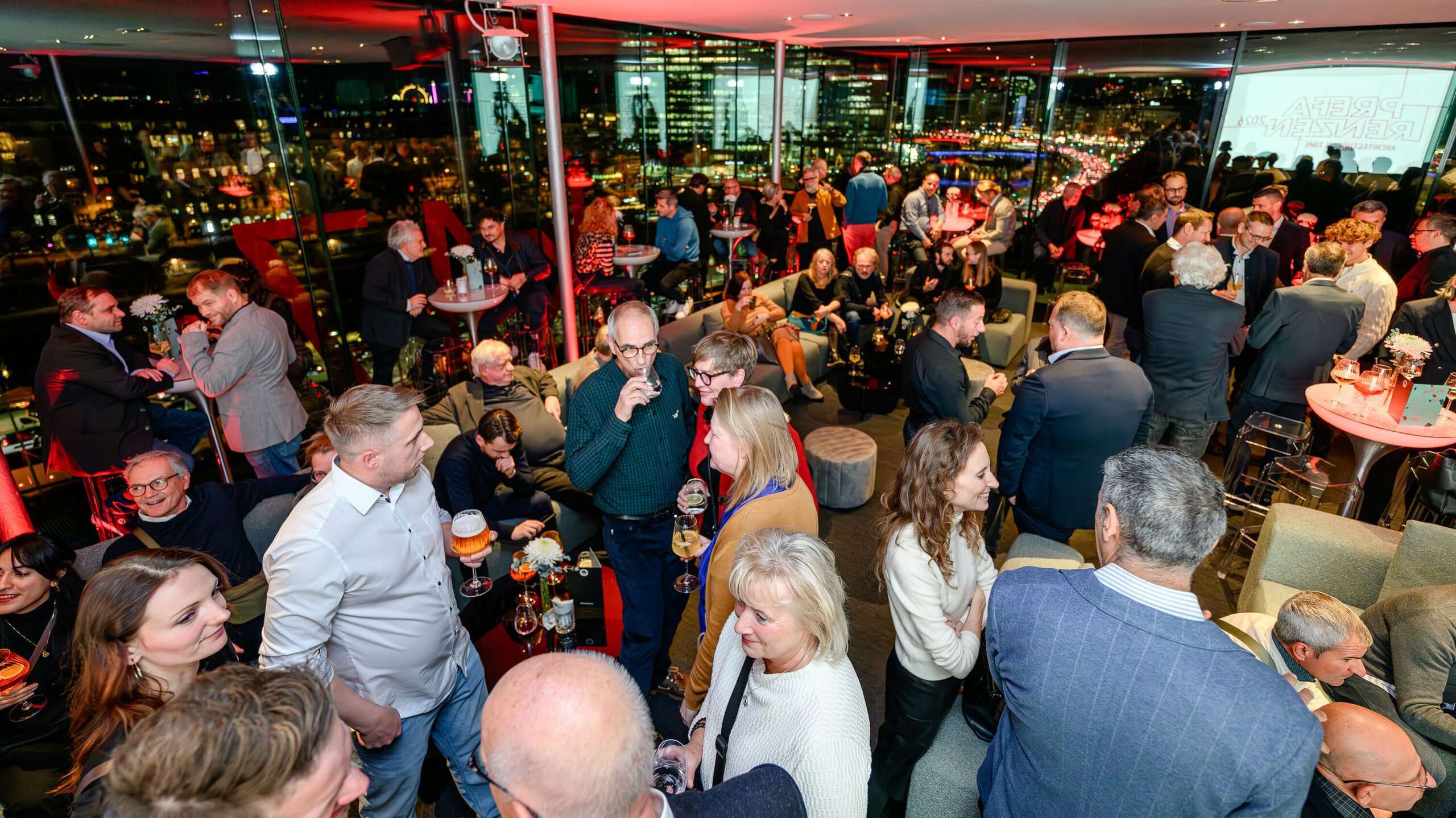 Polna dvorana na predstavitvi PREFARENZEN 2026 v k47.wien: arhitekti, načrtovalci, izvajalci in navdušenci nad oblikovanjem so se živahno pogovarjali ob pijači, razgledu na Dunaj in navdihujoči atmosferi. Panoramska okna odražajo luči mesta in stilsko poudarjajo visokokakovostno prireditev. PREFA z dolgotrajnimi aluminijastimi rešitvami ustvarja platformo za inovacije in dialog. Prireditev na impresiven način prikazuje, kako arhitektura srečuje prihodnost – z močnimi izdelki, kreativnimi idejami in pristnimi povezavami znotraj panoge.