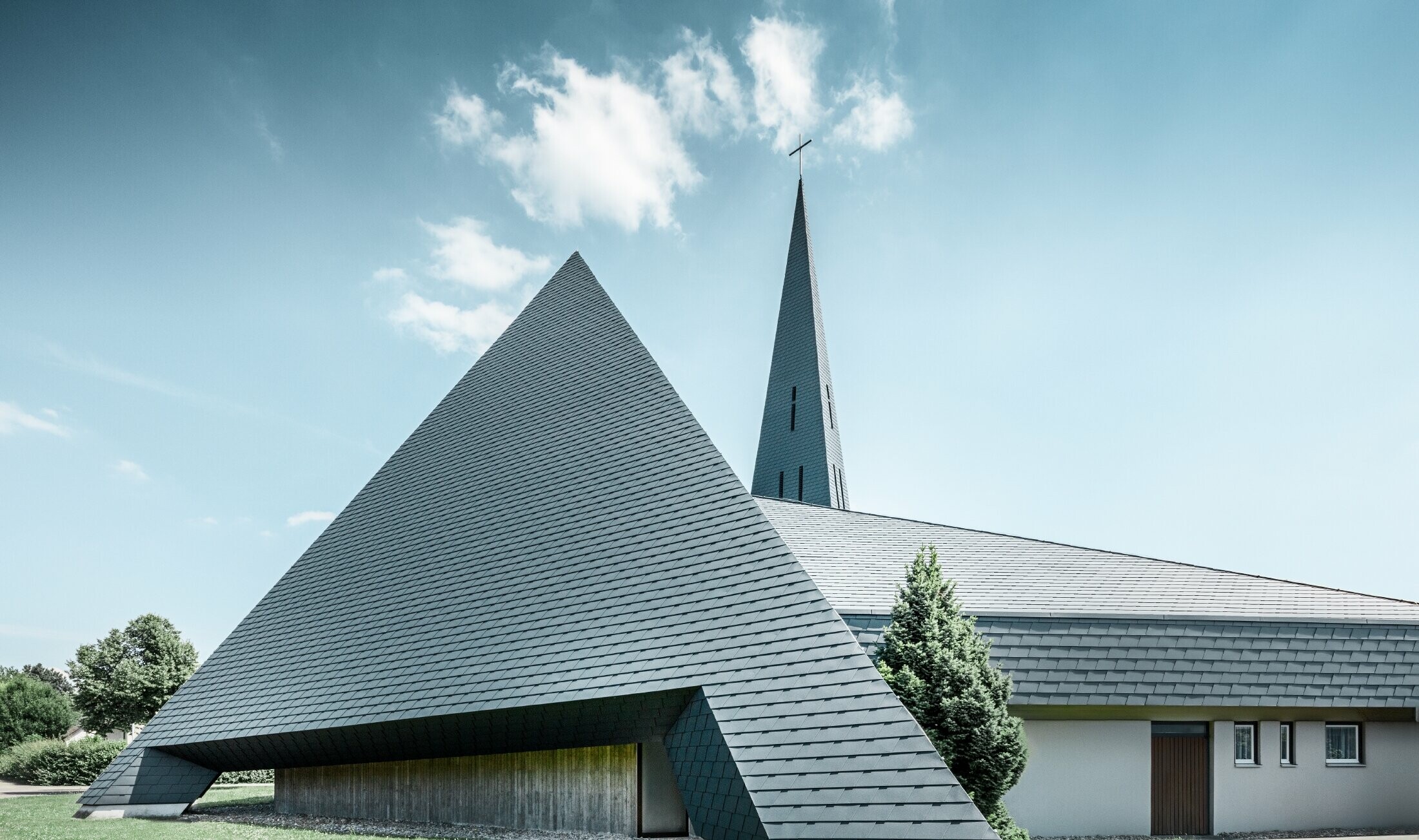 Katoliška cerkev v kraju Langenau s piramidi podobnim dizajnom, prekrita z aluminijastimi skodlami PREFA v antracitni barvi