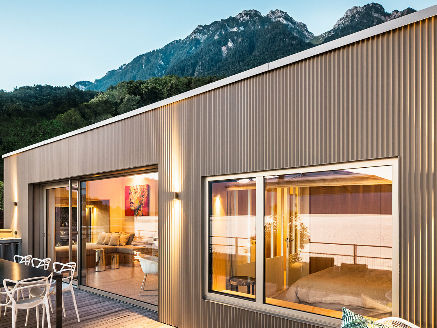 Večerni pogled na teraso in del notranjosti zgradbe.