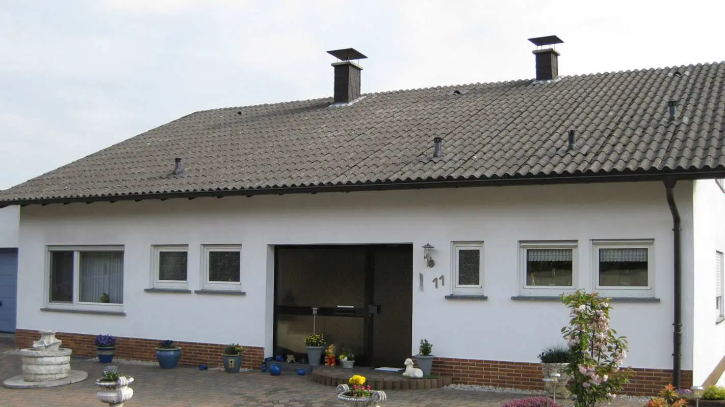 Enodružinska hiša z valovitimi ploščami iz vlaknocementa pred obnovo strehe s strešnimi ploščami PREFA