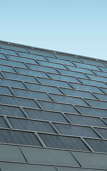 Položena površina solarne strešne plošče PREFA v kombinaciji s strešno ploščo R.16 v barvi P.10 antracitna.