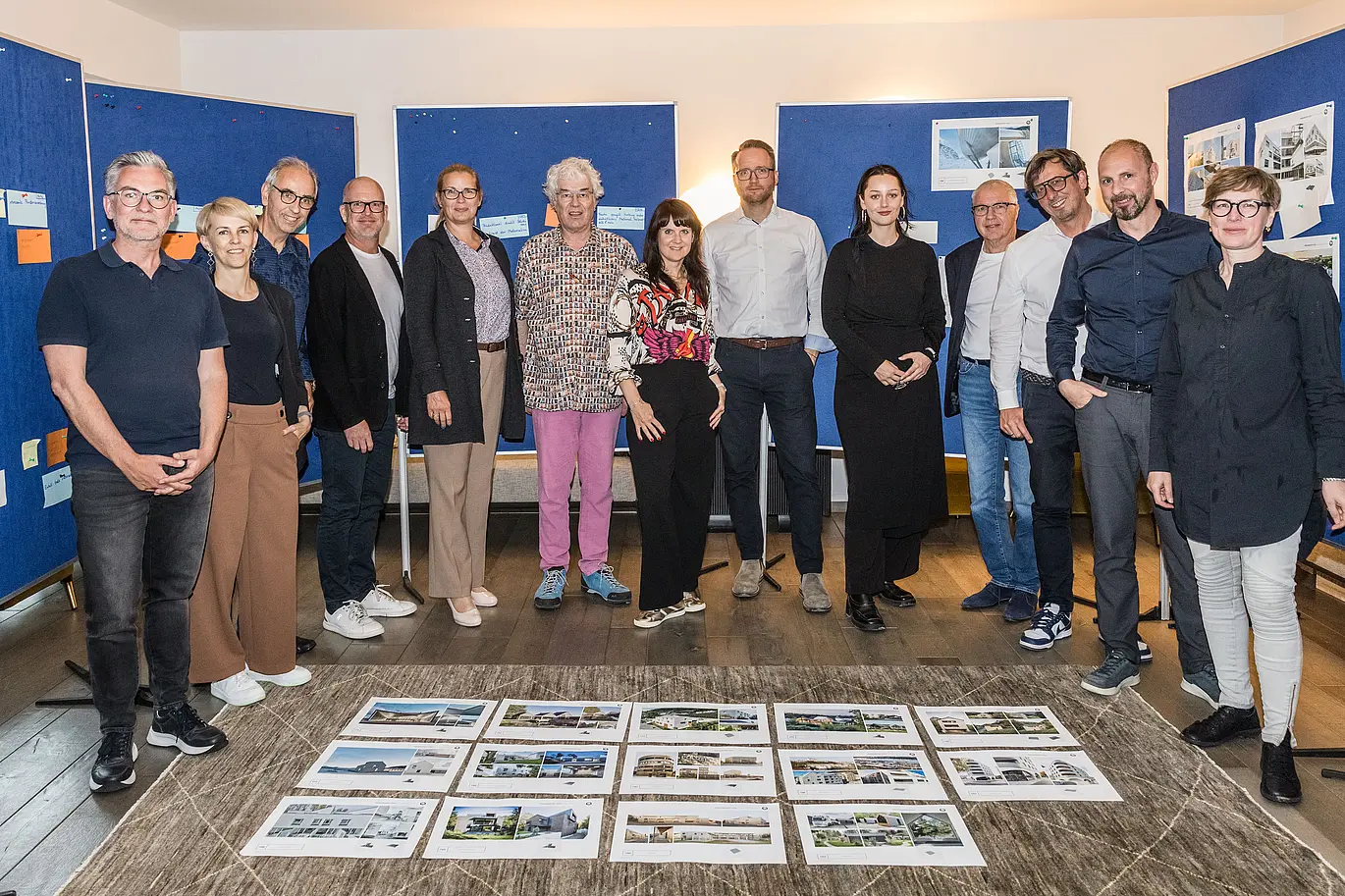 Skupinska fotografija žirije PREFARENZEN 2026 po uspešnem izbirnem postopku v vinogradniški rezidenci v Seewinklu na Gradiščanskem: Dirk Lorenz (Leinert Lorenz Architekten), Veronika Roll (marketing, PREFA Avstrija), Wolfgang Croce (Croce & Wir, Gradec), Jürgen Jungmair (vodja mednarodnega marketinga, PREFA), Judit Nemere (direktorica PREFA Madžarska), Matthias Finkentey (moderator), Bettina Almeida (upravljanje komunikacij, PREFA), Christian Wirth (regionalni vodja za vzhod, PREFA Avstrija), Selina Wach (vodja oddelka za diskurz, Architektur Aktuell), Thomas Schlett (B3 Architekten), Sven Disser (vodja razvoja, Bauwerk), Falk Leinert (Leinert Lorenz Architekten) in Juliane Croce (Croce & Wir, Gradec) stojijo pred končnimi arhitekturnimi projekti, izbranimi za arhitekturno knjigo PREFARENZEN in koledar 2026. Projekti odražajo raznolikost, trajnost in inovativno uporabo materialov PREFA.