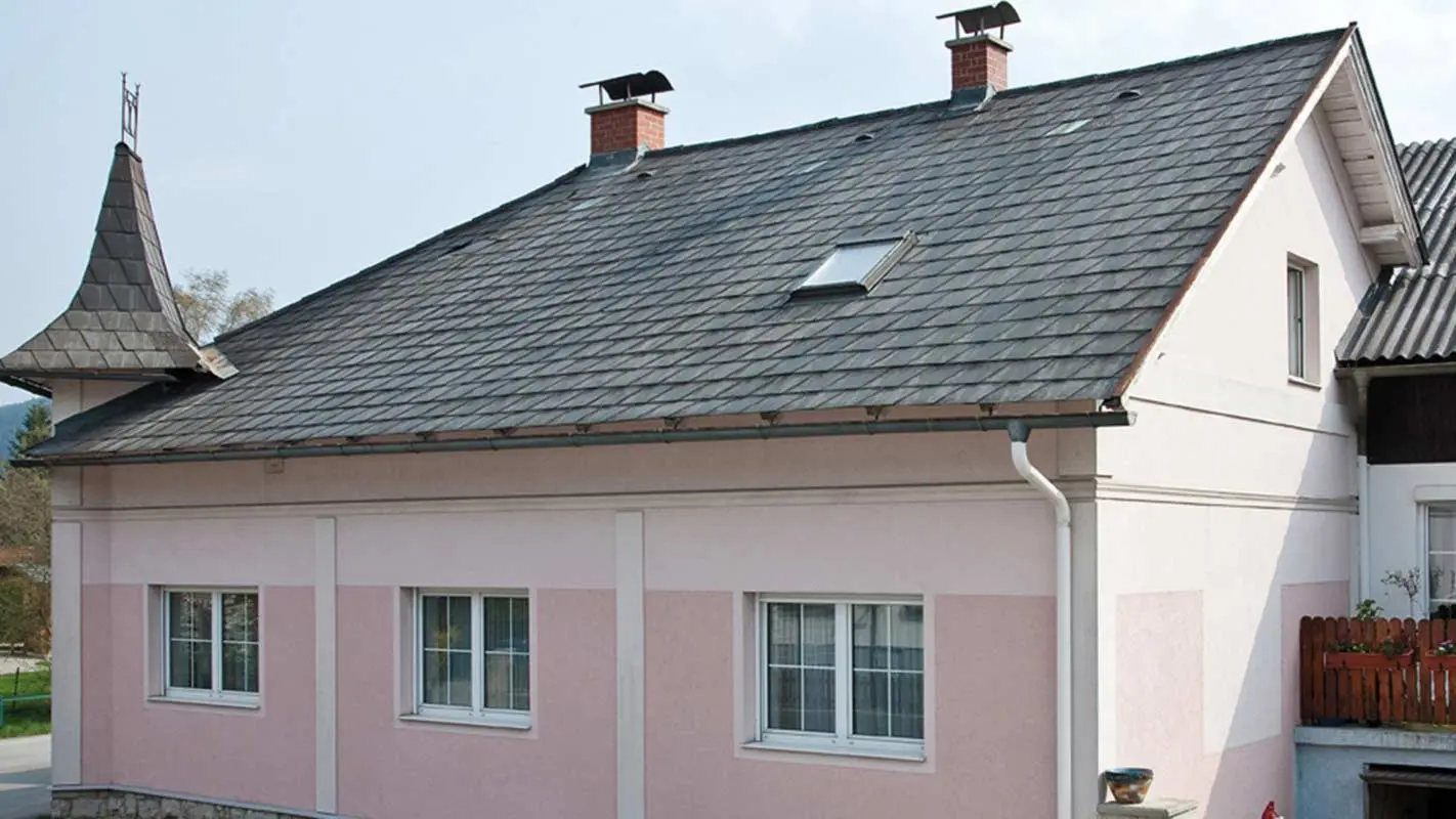 Hiša v Avstriji pred obnovo strehe s strešnimi ploščami PREFA (pred tem – streha s strešniki iz vlaknocementa Eternit s stolpičem in roza fasado)