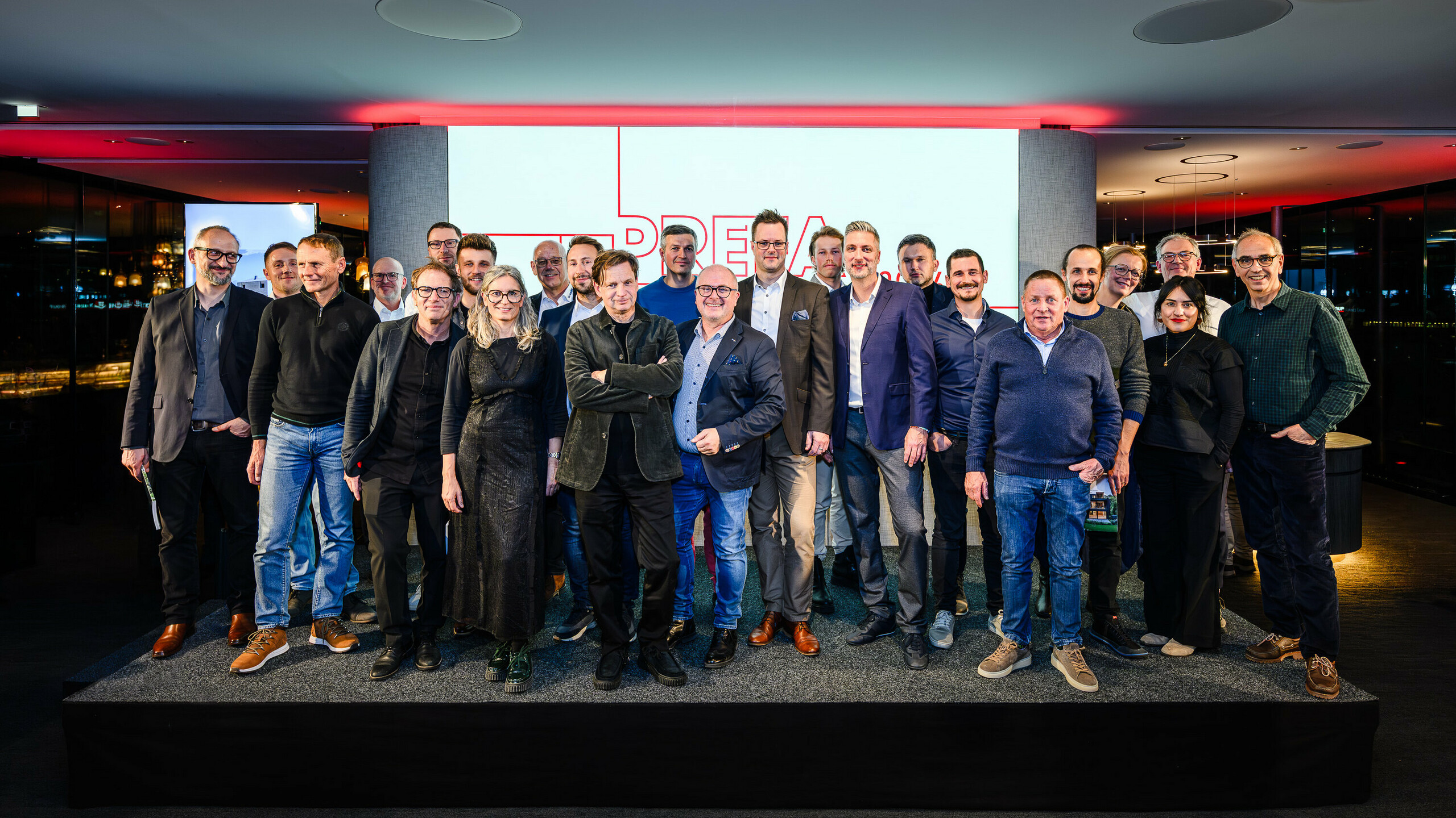 Skupinska fotografija arhitektov, projektantov in izvajalcev na odru PREFARENZEN predstavitve 2026 v k47.wien – močan simbol skupnosti, ustvarjalnosti in napredne arhitekture. Pred svetlečim logotipom PREFARENZEN stojijo oblikovalci, ki stojijo za impresivnimi projekti z aluminijem PREFA. Prizor odraža ponos, inovativnost in sodelovanje. Izdelki PREFA ponujajo trajne, vremensko odporne rešitve z estetsko vrednostjo – idealne za sodobne arhitekturne koncepte. Navdihujoč večer, poln izmenjave, vizij in močnih partnerstev. 