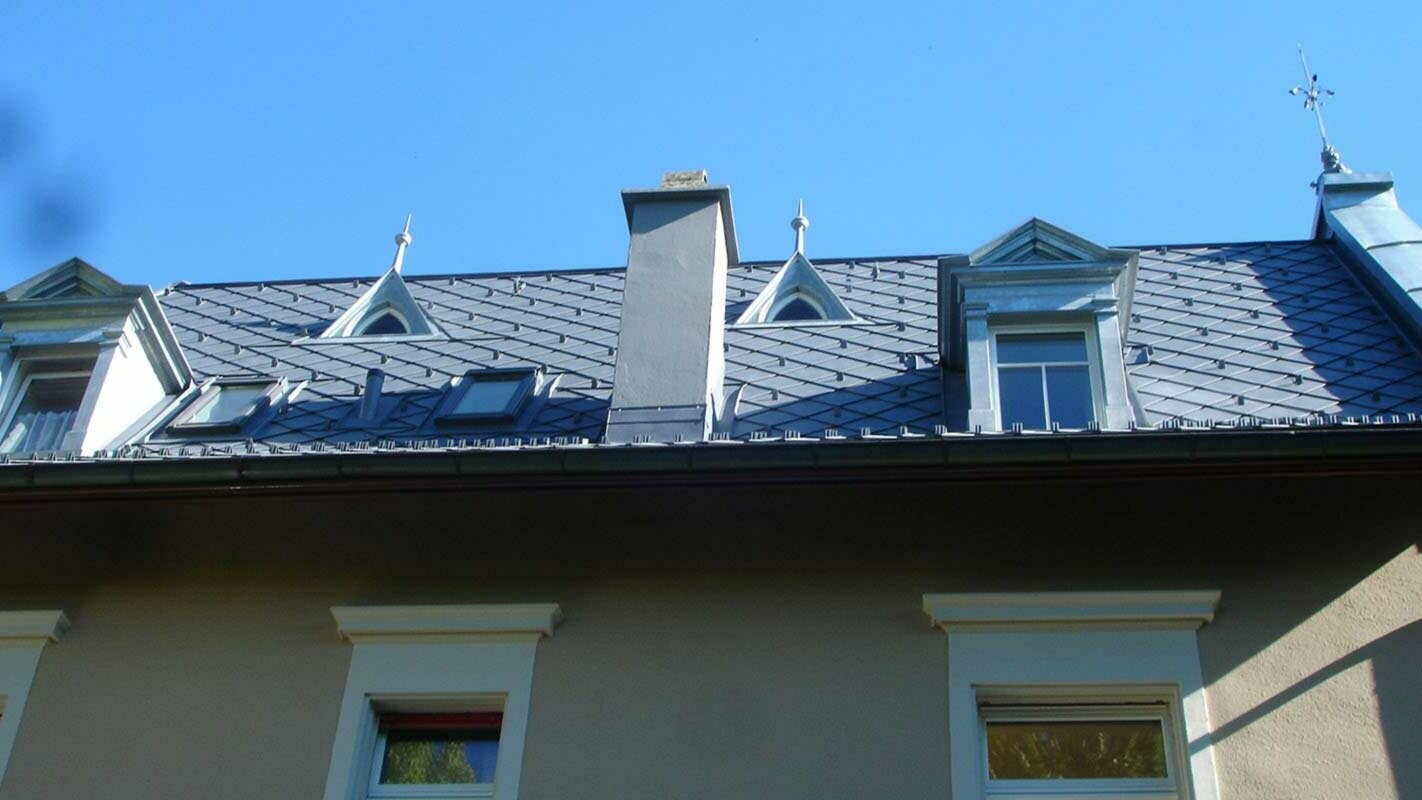 Streha z igrivimi mansardnimi okni – obnova strehe s strešnimi rombi PREFA