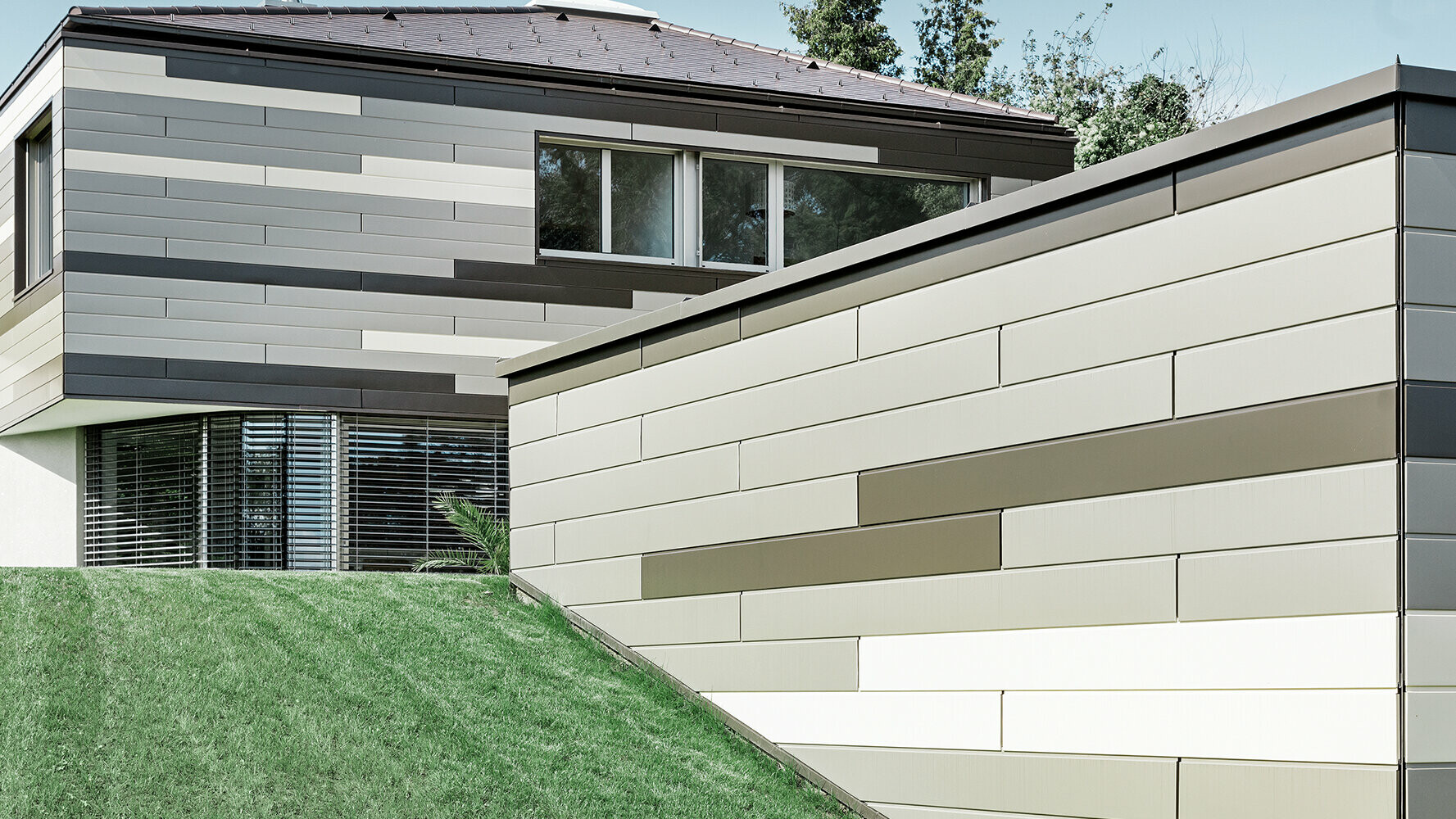 Moderna stanovanjska hiša z elementi PREFA Siding v treh različnih barvah na fasadi