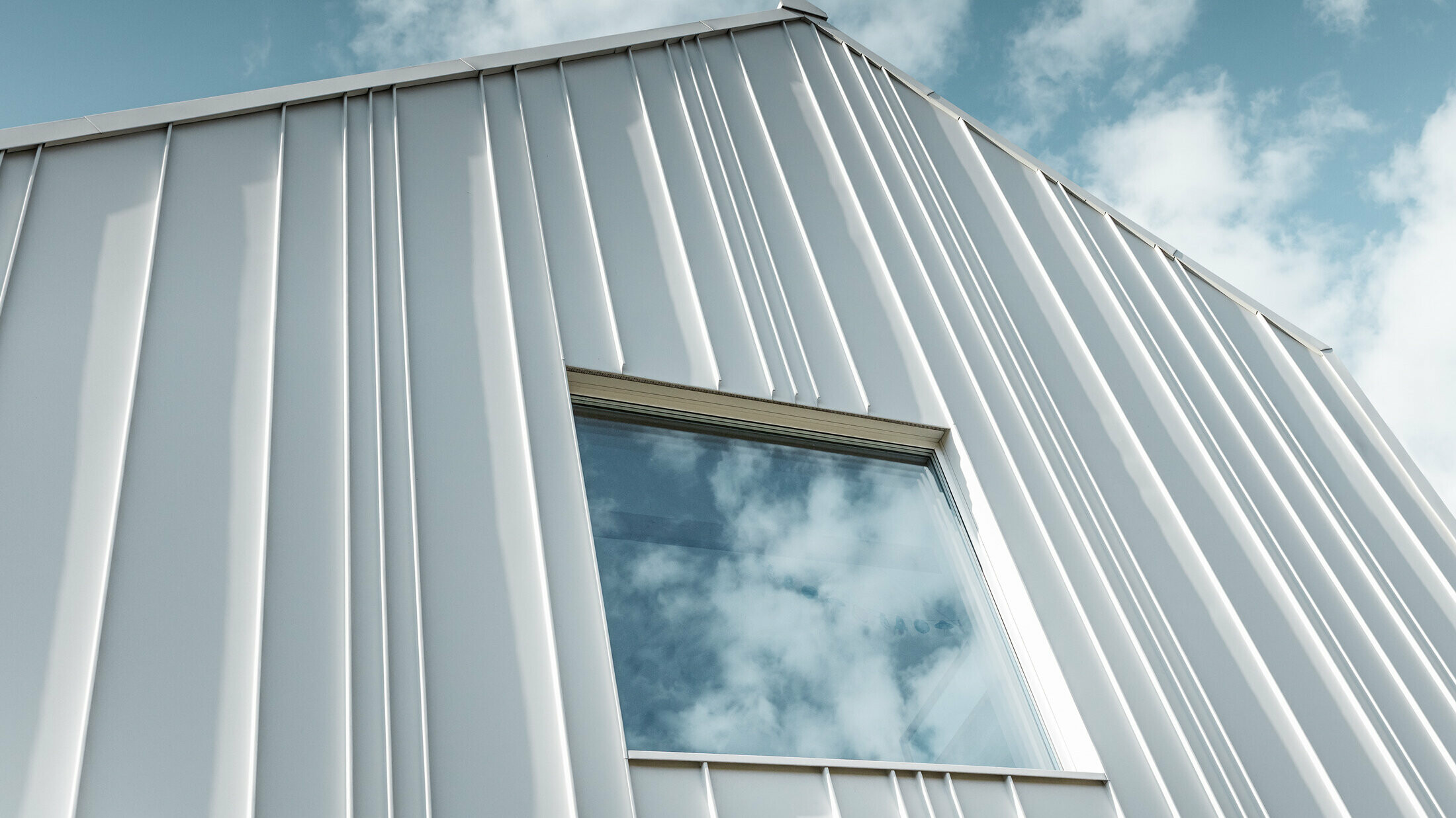 izvedba PREFALZ v beli barvi s pravokotnim pokončnim zgibom na fasadi z različnimi širinami trakov in oknom