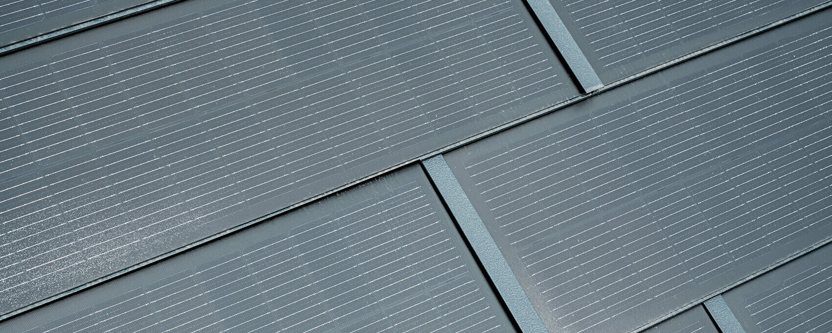 Natančen posnetek položene male solarne strešne plošče. Mala solarna strešna plošča v barvi P.10 antracitna je bila kombinirana s strešno ploščo R.16. 