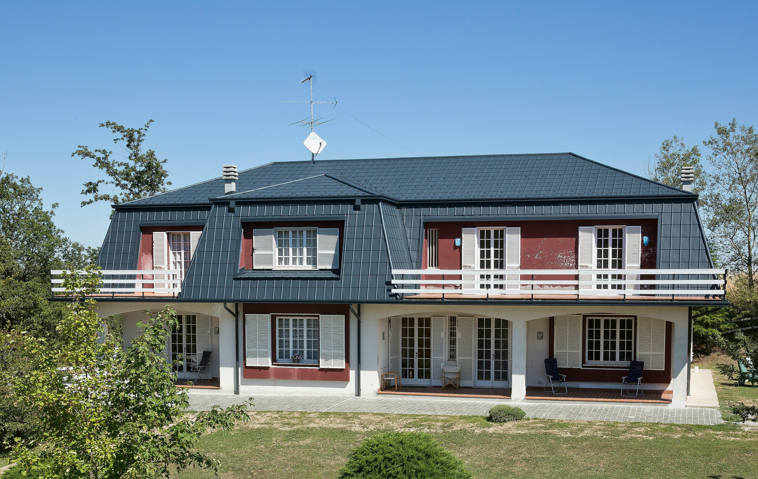 Vila v Italiji z mansardno streho, prekrita s strešnimi ploščami PREFA Strešne plošče PREFA v antracitni barvi iz aluminija krasijo streho te vile v Italiji