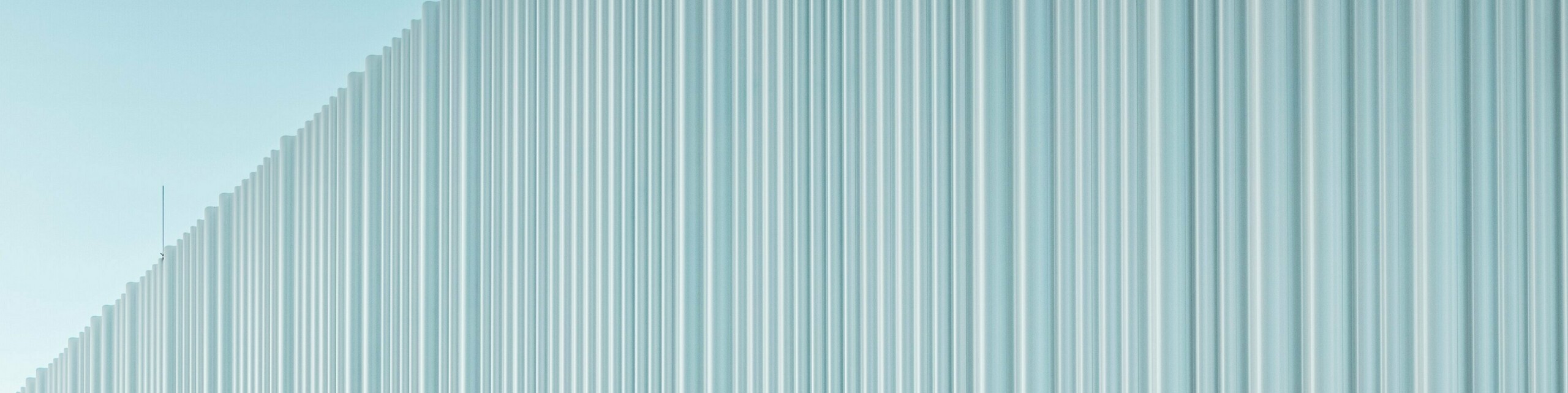 Spektakularno oblikovana fasada z PREFA ekstrudirano stikanim valovitim profilom iz visokokakovostnega aluminija krasi poslovno stavbo podjetja LKW Walter na Dunaju. Nežno ukrivljena, navpično potekajoča struktura profila ustvarja eleganten valovit vzorec z očarljivo igro svetlobe in senc. Medtem ko sodobna stavba prepriča z jasno oblikovno govorico, ukrivljen izsek fasade ustvari izrazit arhitekturni kontrast. Trajni in proti koroziji odporni aluminijasti profili s skrito pritrditvijo zagotavljajo kakovostno in vzdrževanja skoraj ne zahtevajočo zunanjo ovojnico.