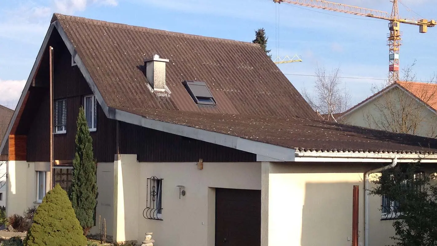 Hiša z dvokapno streho in garažo pred obnovo strehe s strešnimi ploščami PREFA