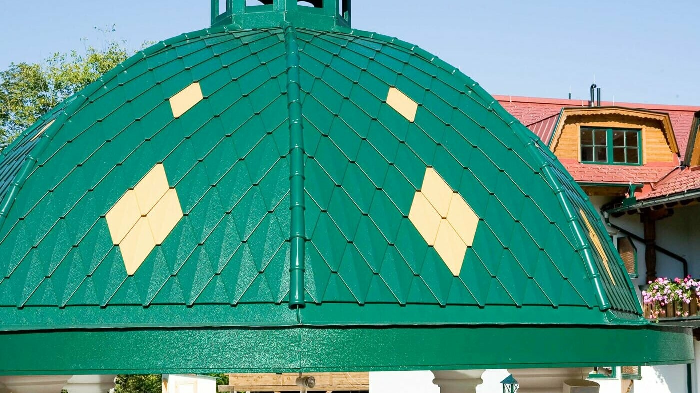 Okrogla kupola, obložena z malim rombom PREFA v mahovo zeleni barvi