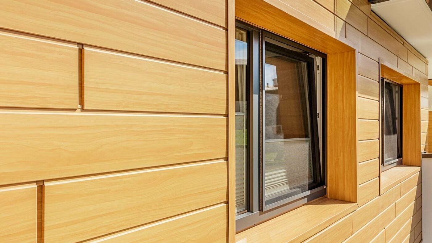 Aluminijasta fasadna površina z Siding PREFA v videzu lesa z okenskim okvirom;
