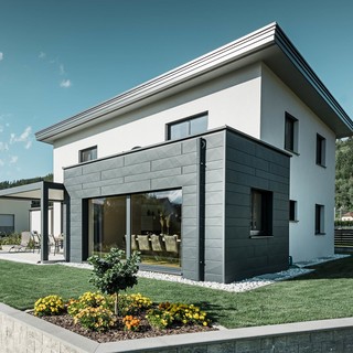 Enodružinska hiša s prizidkom, prizidek je izveden z aluminijasto fasado PREFA, odvodnjavanje ravne strehe je izvedeno z nastavkom za izliv PREFA in odtočno cevjo PREFA v barvi P.10 antracit,