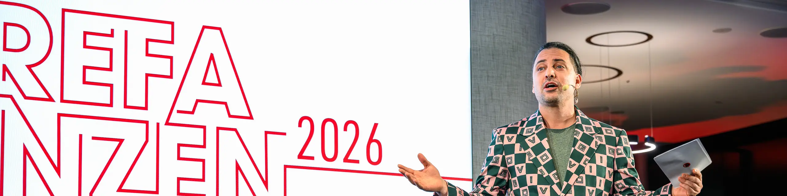Gledališki trenutek z učinkom wow na predstavitvi PREFARENZEN 2026: voditelj Serkan Temel navdušuje občinstvo s svojim šarmom, humorjem in opazno obleko. Njegova prisotnost poudarja ustvarjalni duh dogodka, ki združuje inovativnost, oblikovanje in skupnost. Vrhunski večer v k47.wien, ki prikazuje, kako sodobna in vsestranska je danes aluminijasta arhitektura s PREFA.