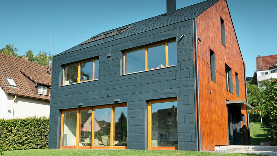 Fasada PREFA FX.12 v P.10 antracitni se razteza od fasade čez dvokapno streho – popolnoma brez napušča.