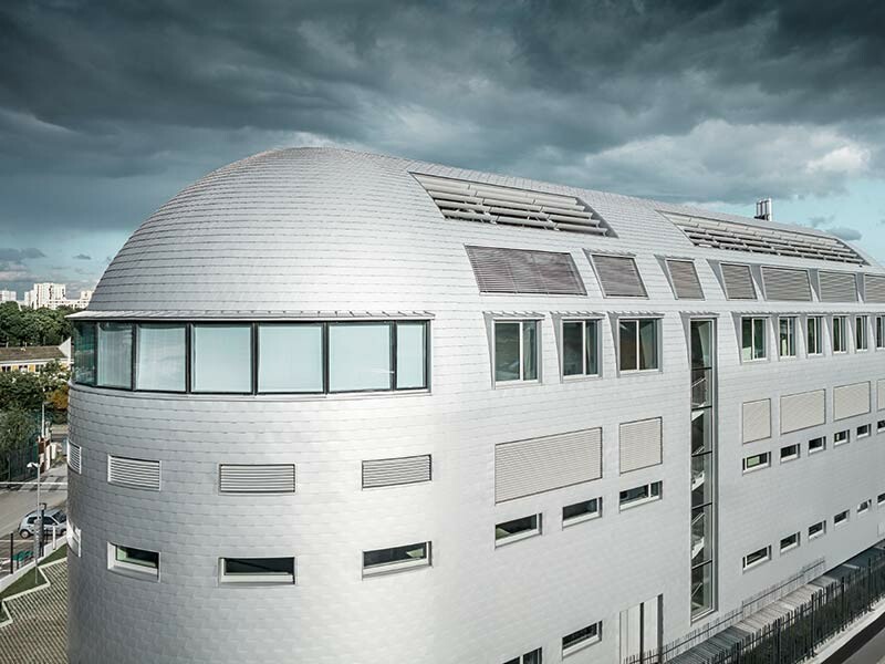 Sodobna zasnova tehnološkega centra v Parizu je bila prekrita s PREFA strešnim in fasadnimi skodlami in poudarila zaokroženo obliko