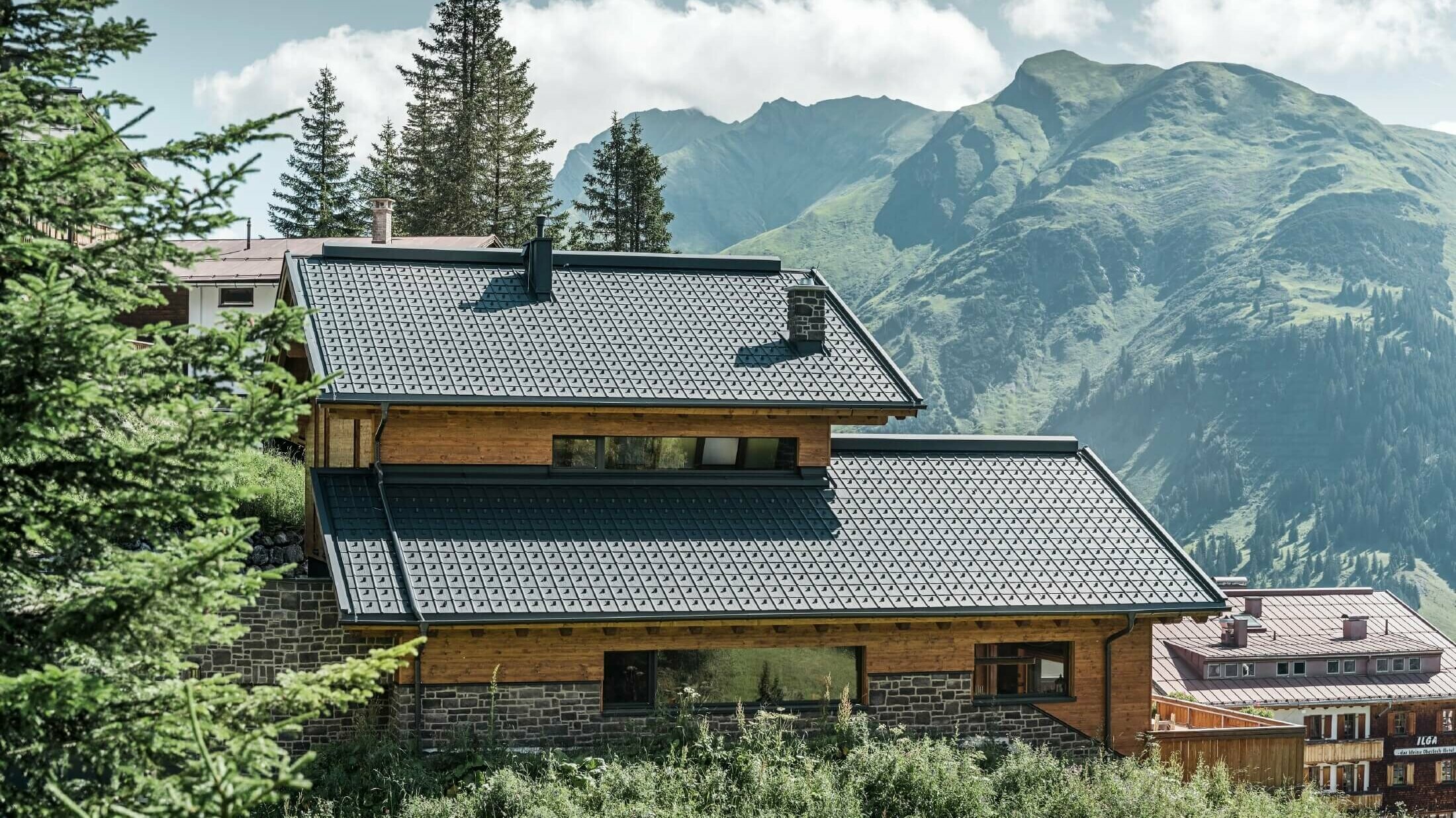 Hiša v alpski legi s strešnimi ploščami PREFA v antracitni barvi kot strešno kritino