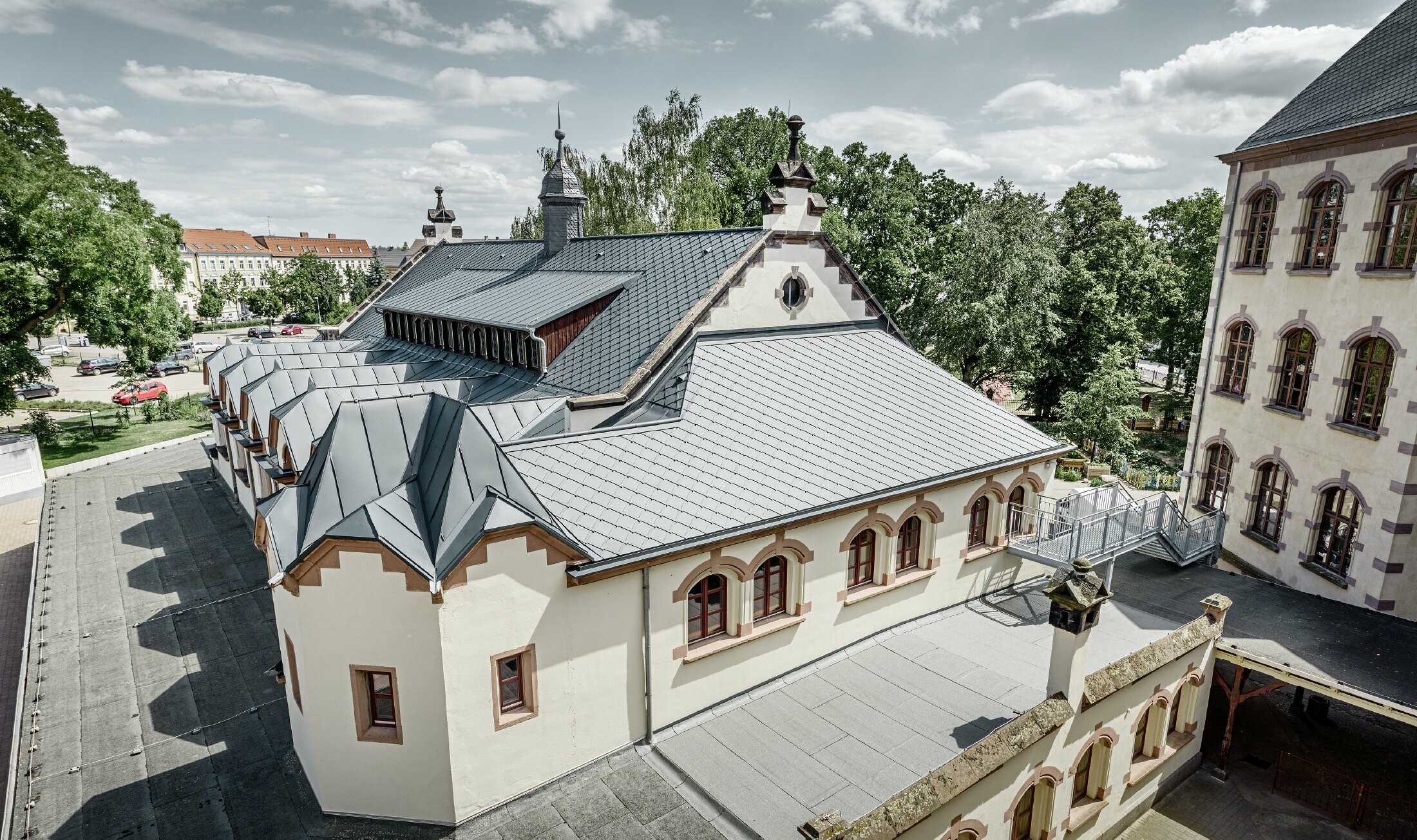 Novo sanirana telovadnica šole Lutherstadt Wittenberg z aluminijasto streho PREFA, strešni rombi in elementi Prefalz položeni v antracitni barvi