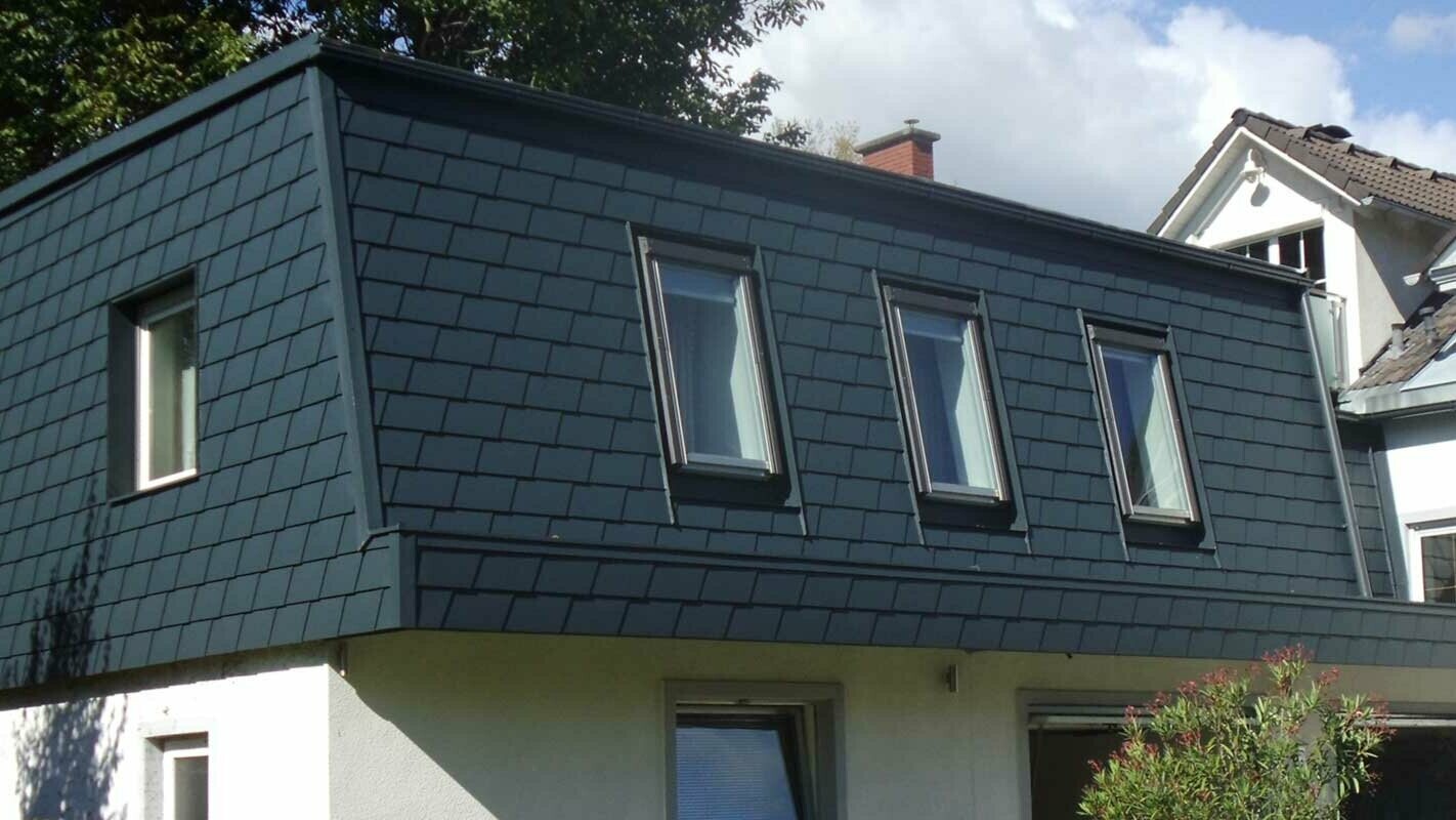 Izgradnja strehe s strešnimi skodlami PREFA, moderno nadstropje v antracitni barvi s številnimi okni
