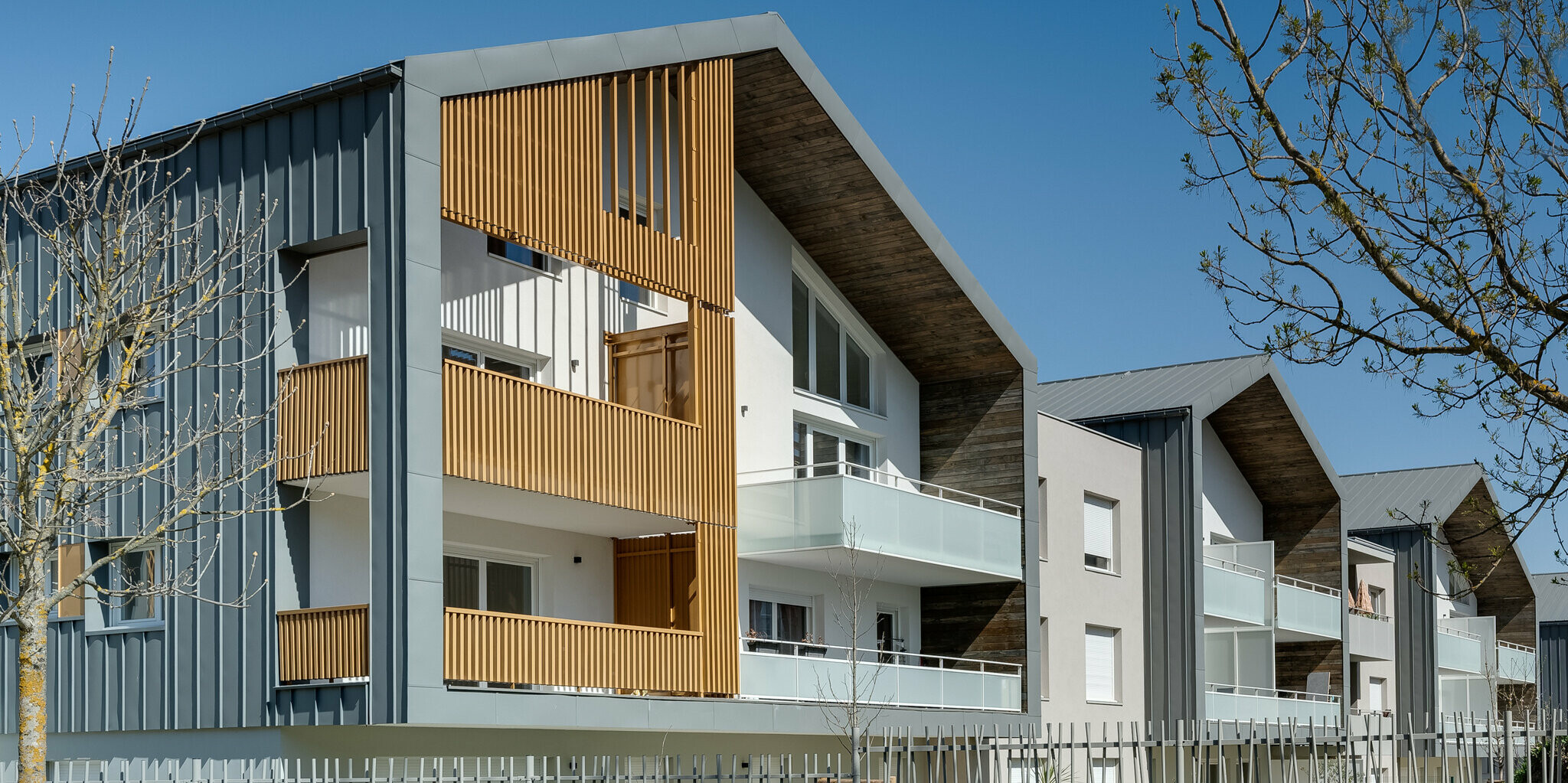 Rezidenco L’Athéna sestavlja več delov stavb, ki so pokriti s trakovi PREFALZ v P.10 svetlo sivi barvi. Stanovanjsko sosesko je zgradilo podjetje ARCANE Architectes v Varces-Allières-et-Rissetu v Franciji.