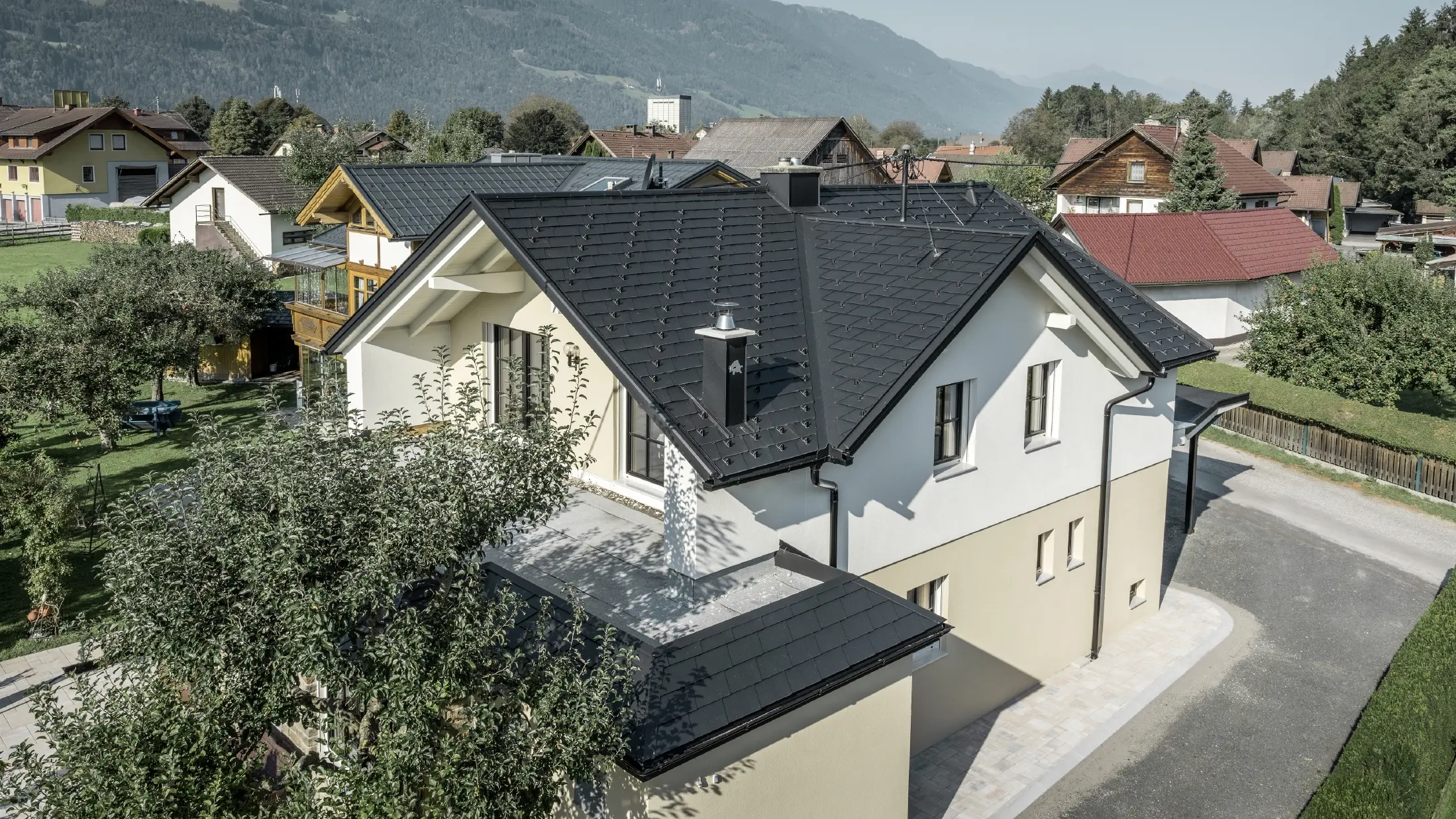 Tradicionalna enodružinska hiša z dvokapno streho in velikim mansardnim oknom, na novo obnovljena. Streha je pokrita s črnimi strešnimi skodlami PREFA.