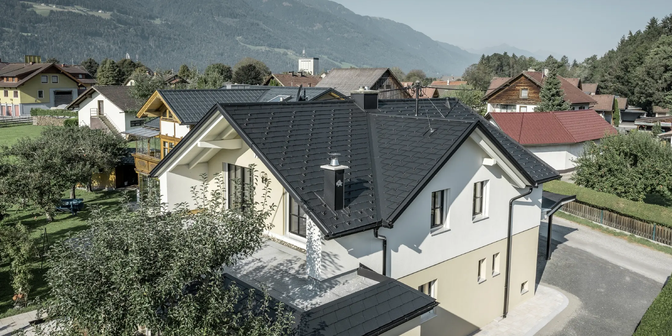 Tradicionalna enodružinska hiša z dvokapno streho in velikim mansardnim oknom, na novo obnovljena. Streha je pokrita s črnimi strešnimi skodlami PREFA.