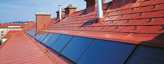 Pogled detajla na PREFA strešni skodli v opečni rdeči barvi, vključno s snegolovi na Hugo Breitner Hof.