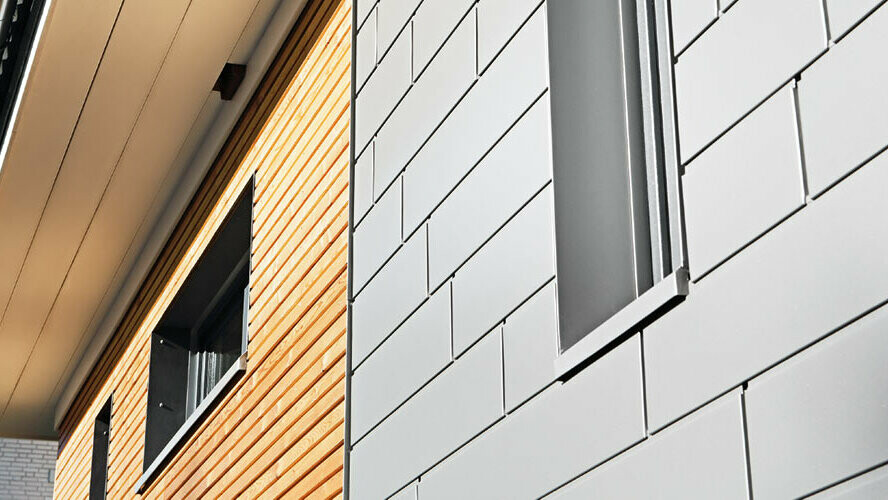 Kombinacija aluminija – PREFA Siding iz sivega aluminija – z leseno fasado. Vodoravna montaža, zamaknjene fuge.