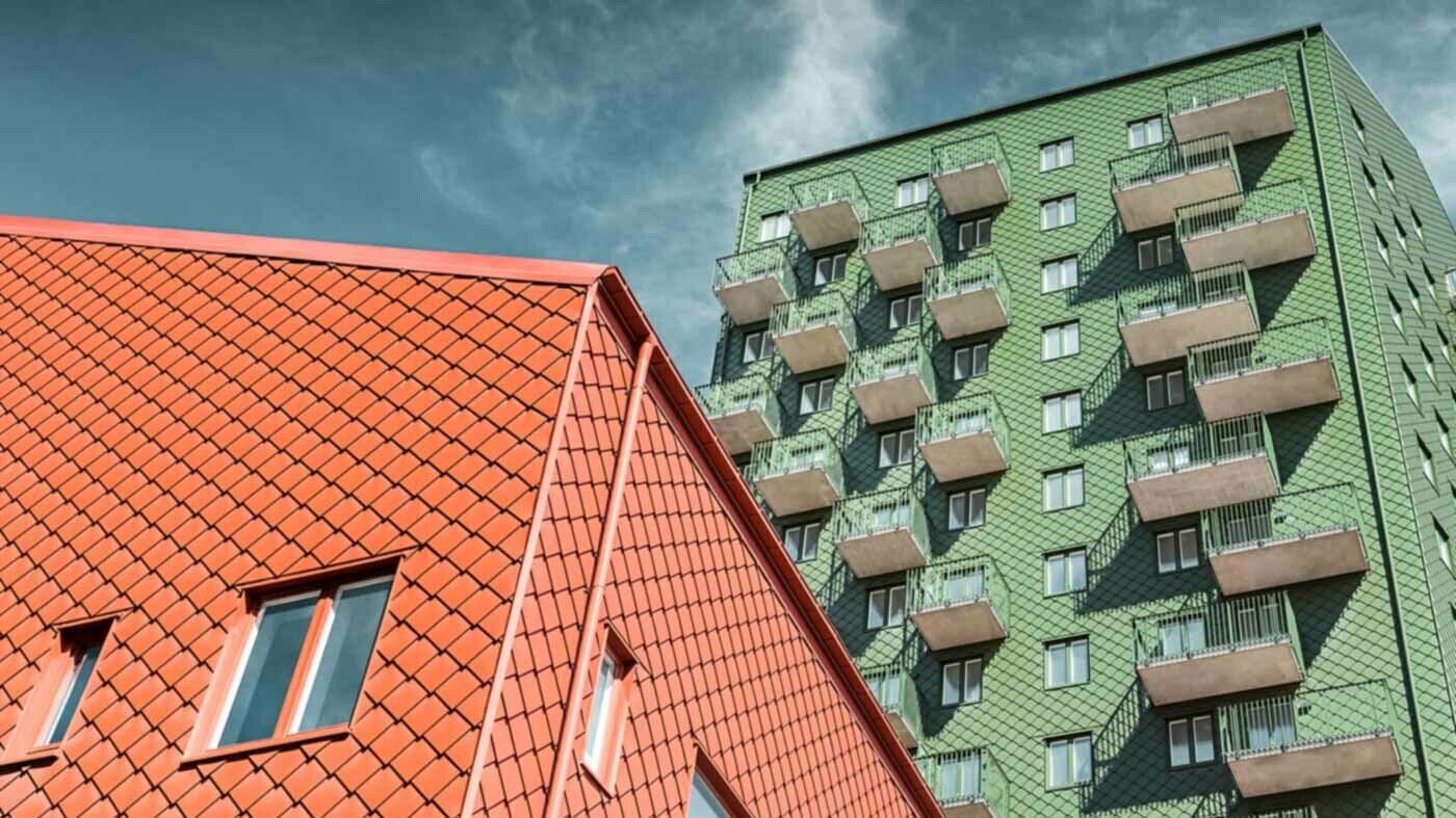 Schwedische Wohnhäuser mit Balkonen und der PREFA Wandraute in Grün und Ziegelrot.