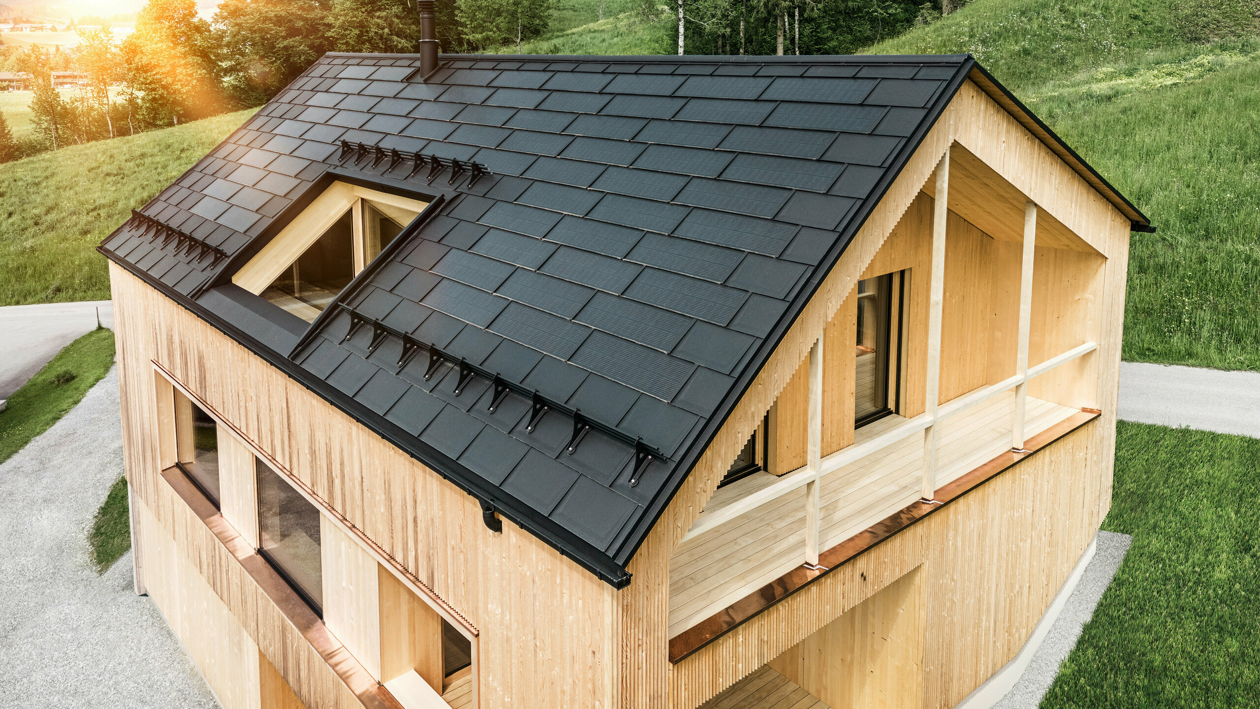 Solarna strešna plošča PREFA in strešna plošča PREFA R.16 nameščeni na enodružinski hiši z leseno fasado v avstrijskem kraju Egg.