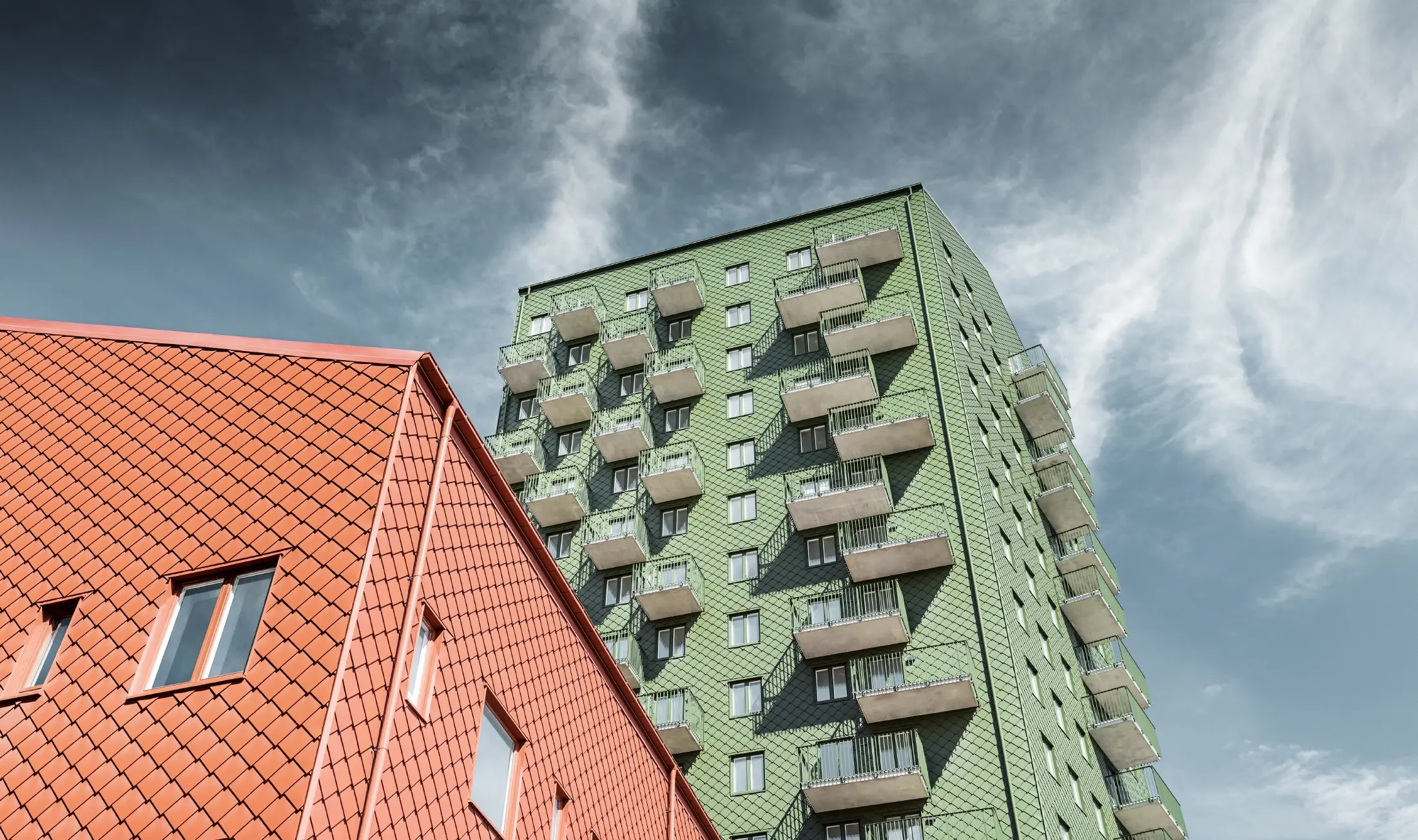 Stolpnice z balkoni in fasado s fasadnimi rombi 29 x 29 PREFA olivno zelene in opečnato rdeče barve