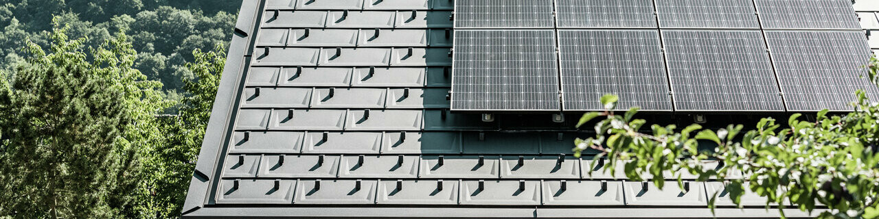 Blick auf ein Einfamilienhaus gedeckt mit der DS.19 mit dem PREFA Solarmontagesystem.