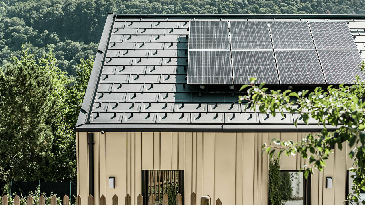 Blick auf ein Einfamilienhaus gedeckt mit der DS.19 mit dem PREFA Solarmontagesystem.