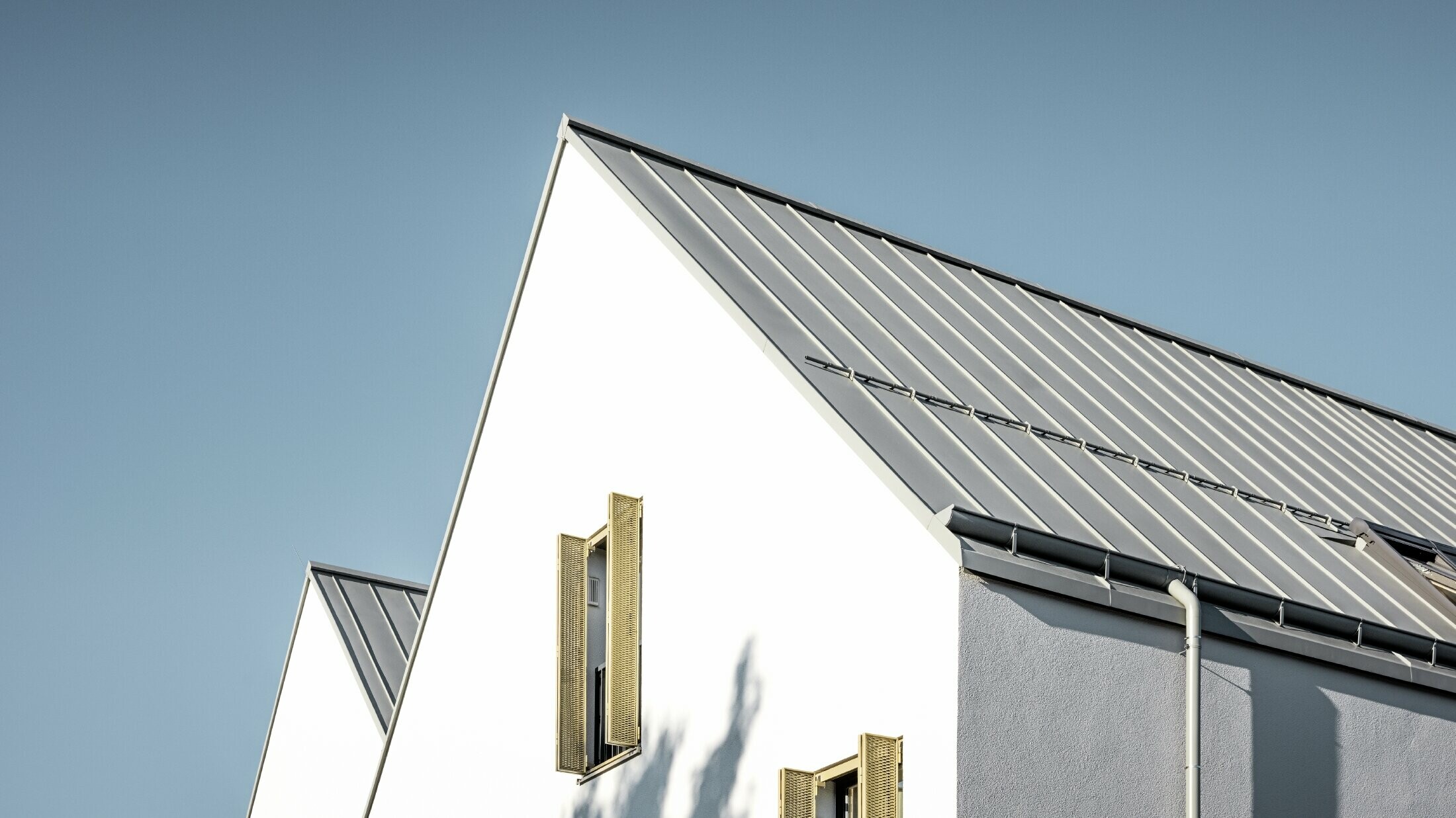 Dvokapna streha brez previsa, obložena s PREFALZ v P.10 cinkovo sivi barvi z ležečim žlebom PREFA