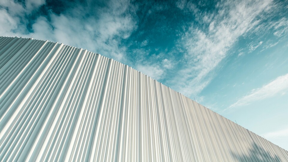 Dih jemajoča arhitektura z belo aluminijasto fasado PREFA v poslovnem parku Walter pri Dunaju. Fasada iz po meri izdelanih individualnih profilov s svojim tekočim, valovitim značajem ustvarja fascinantno igro svetlobe in senc. Tri različne oblike profilov zagotavljajo izjemen prostorski učinek ter stavbi dajejo slogovno čisto, a hkrati dinamično podobo. Trajna, vremensko odporna površina PREFA združuje sodobno estetiko s funkcionalno popolnostjo – pravi vrhunec sodobnega oblikovanja fasad, ki jasno izraža arhitekturno kakovost in tehnično dovršenost.