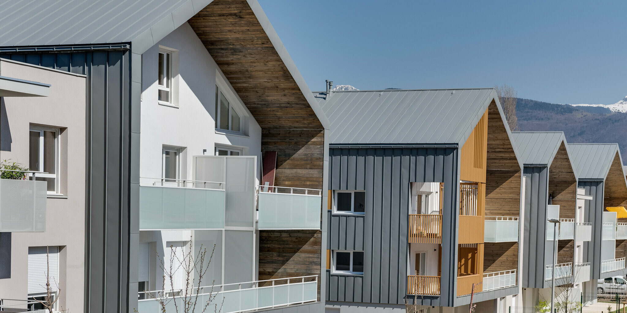 Rezidenco L’Athéna sestavlja več delov stavb, ki so pokriti s trakovi PREFALZ v P.10 svetlo sivi barvi. Stanovanjsko sosesko je zgradilo podjetje ARCANE Architectes v Varces-Allières-et-Rissetu v Franciji.