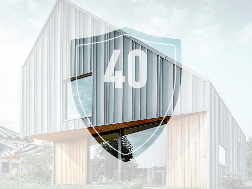 Na sliki je znak s številko „40“, ki naj bi predstavljal garancijo za aluminijaste izdelke PREFA, pred sodobno enodružinsko hišo.