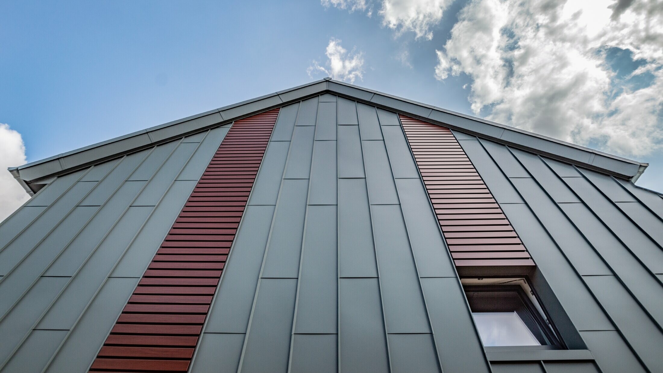 Fasada v obliki vertikalnega pravokotnega pokončnega zgiba s ploščami v svetlo sivi barvi, horizontalni SIDING v barvi temnega lesa PREFA.