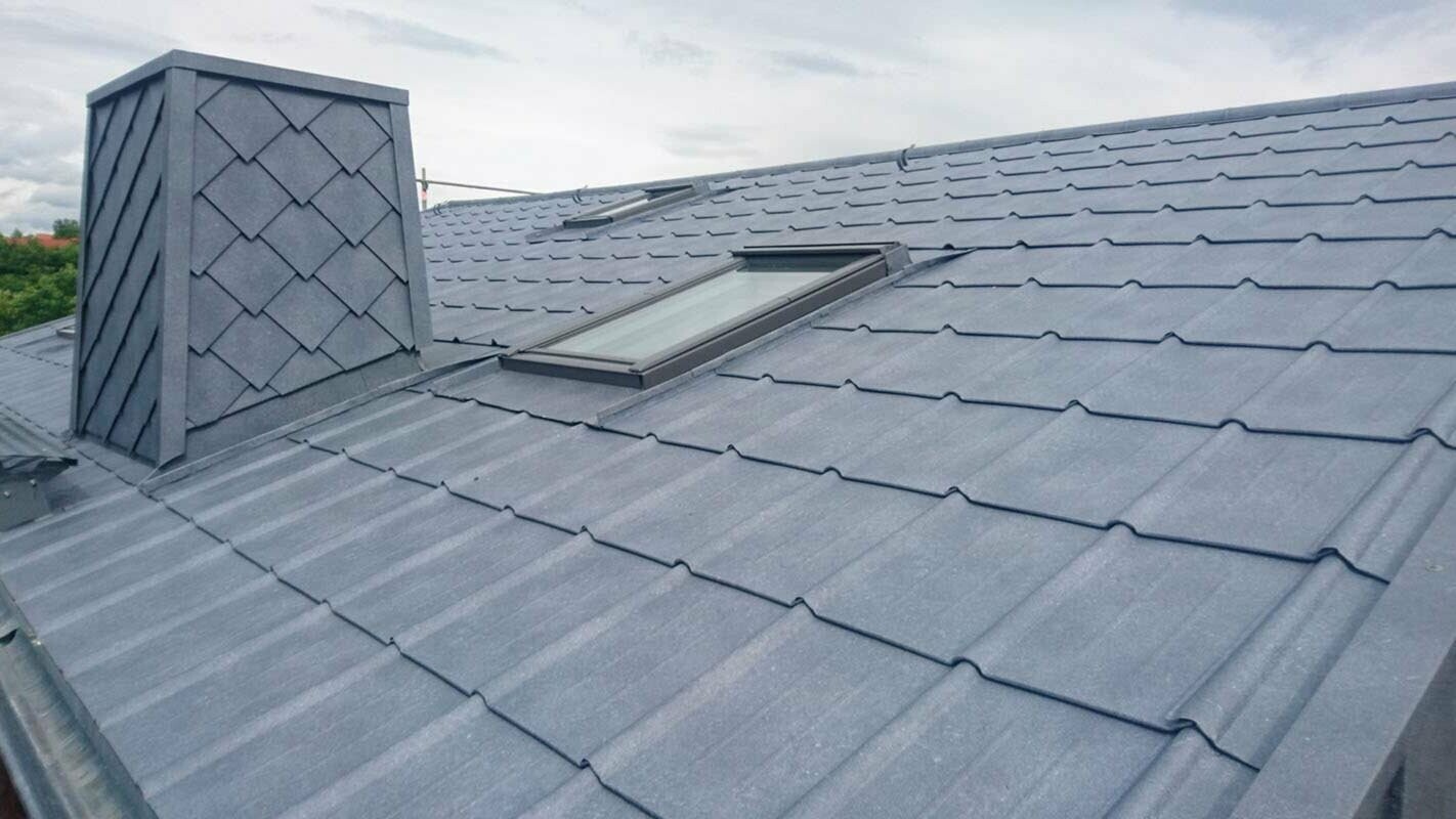 Detajlni posnetek obnove strehe s strešnimi ploščami PREFA v kamniti sivi barvi P.10, vključno z oblogo dimnika