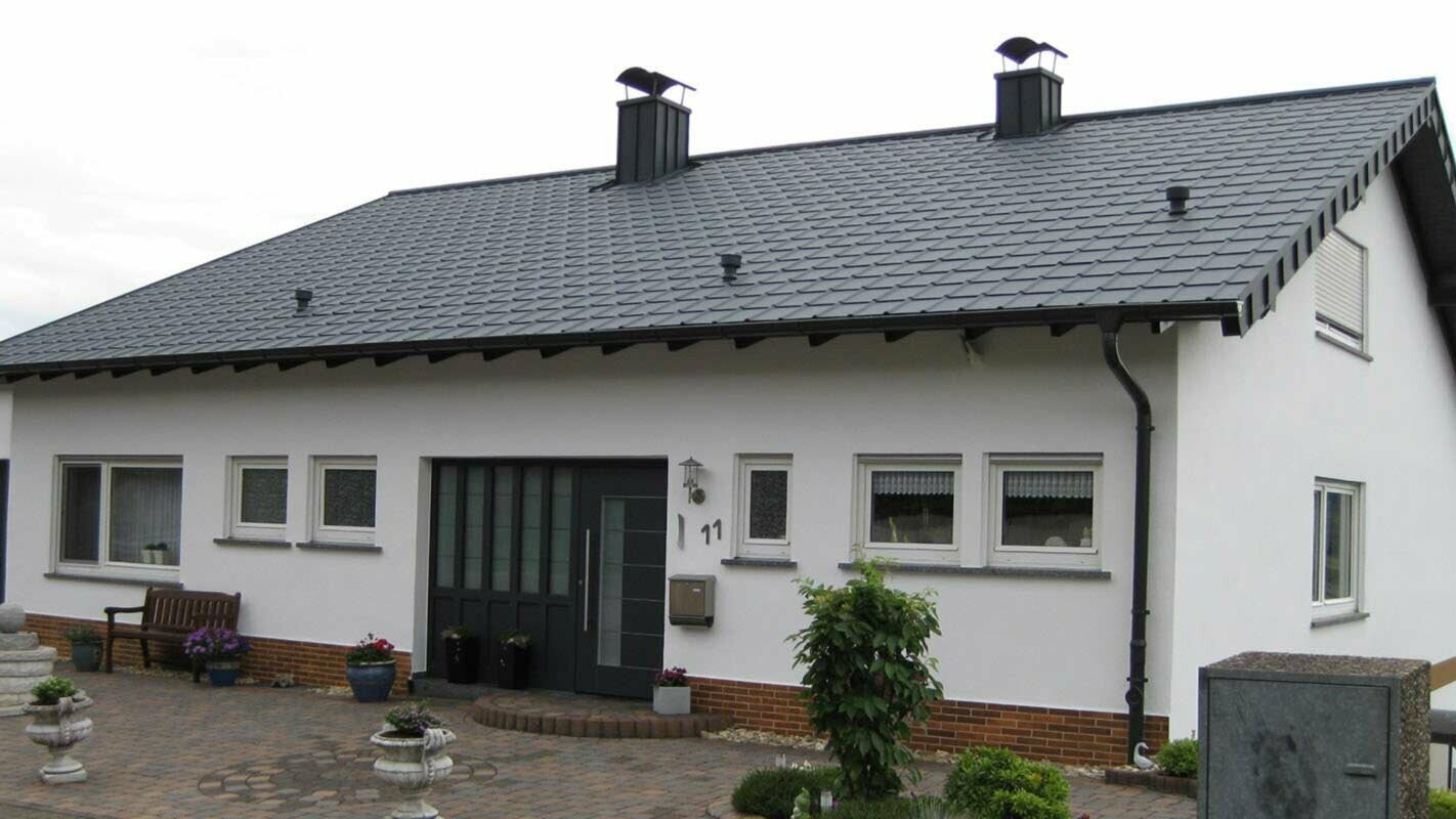 Enodružinska hiša z enostavno dvokapno streho po obnovi strehe s strešnimi ploščami PREFA