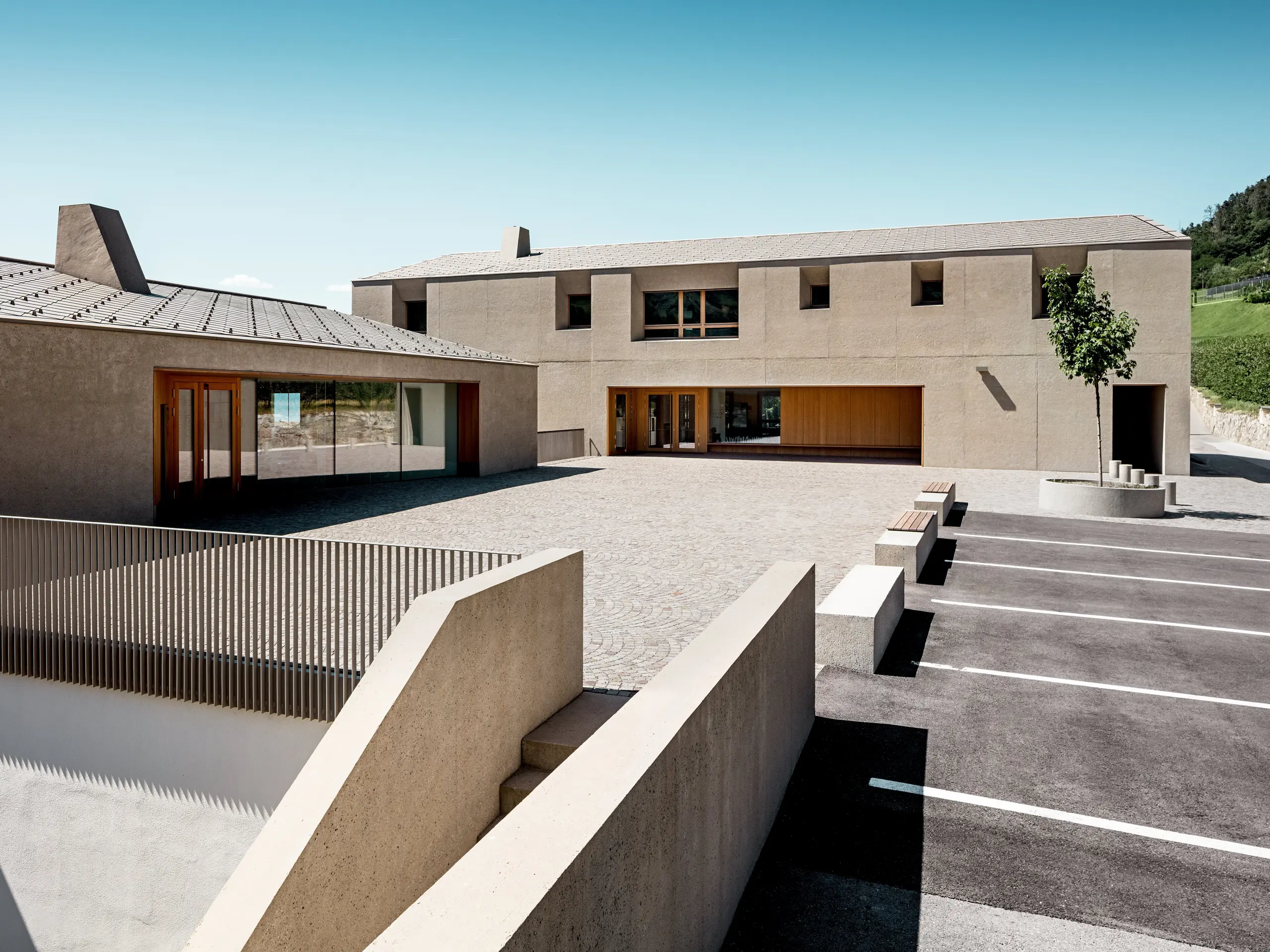 Izobraževalni center Riffian na Južnem Tirolskem združuje sodobno arhitekturo in premišljeno oblikovanje strehe. Oba stavbna objekta s strešnimi rombi PREFA 44 × 44 v barvi P.10 bronasta se harmonično vključujeta v okoliško pokrajino. Trpežna aluminijasta strešna kritina zagotavlja zanesljivo zaščito pred vremenskimi vplivi ter poudarja čiste arhitekturne linije šolskega objekta.