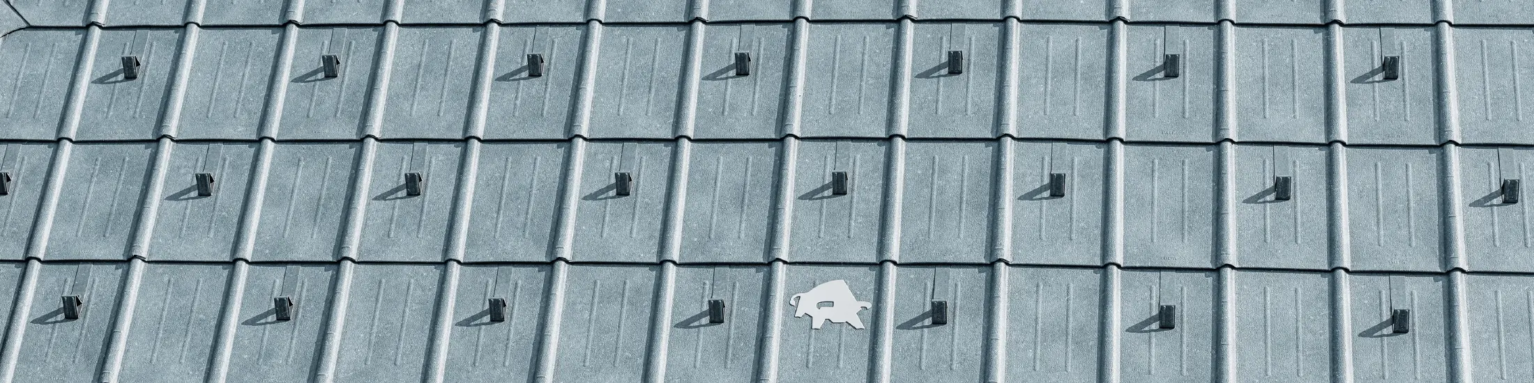 Strešna plošča PREFA z logotipom bika PREFA v kamnito sivi barvi P.10; strešna površina s pločevinasto streho PREFA