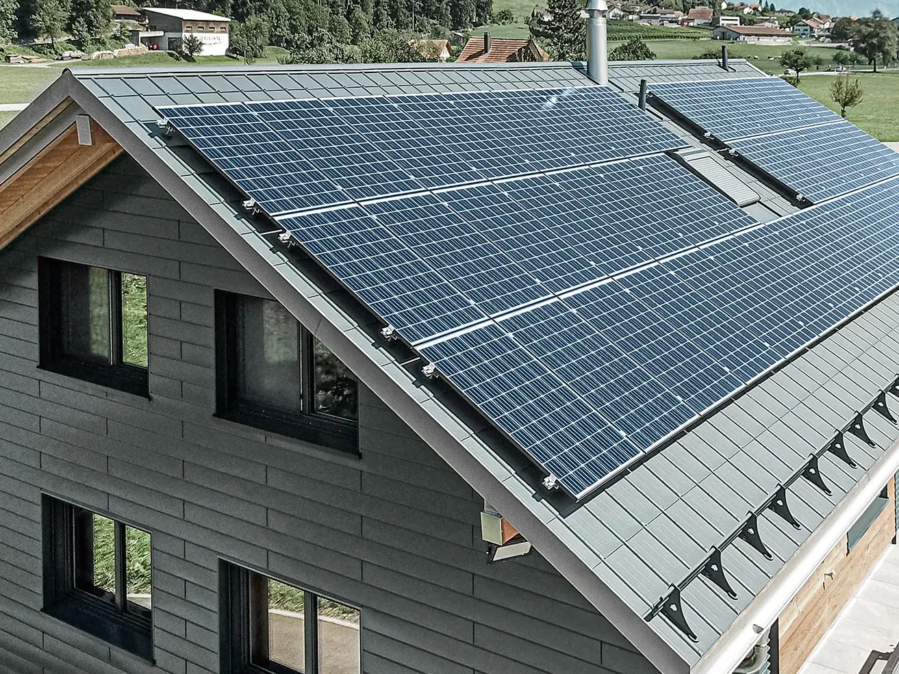 Fotonapetostni sistem, montiran na strehi PREFA, z nosilci solarnih sistemov in nosilnim profilom za stabilno namestitev.