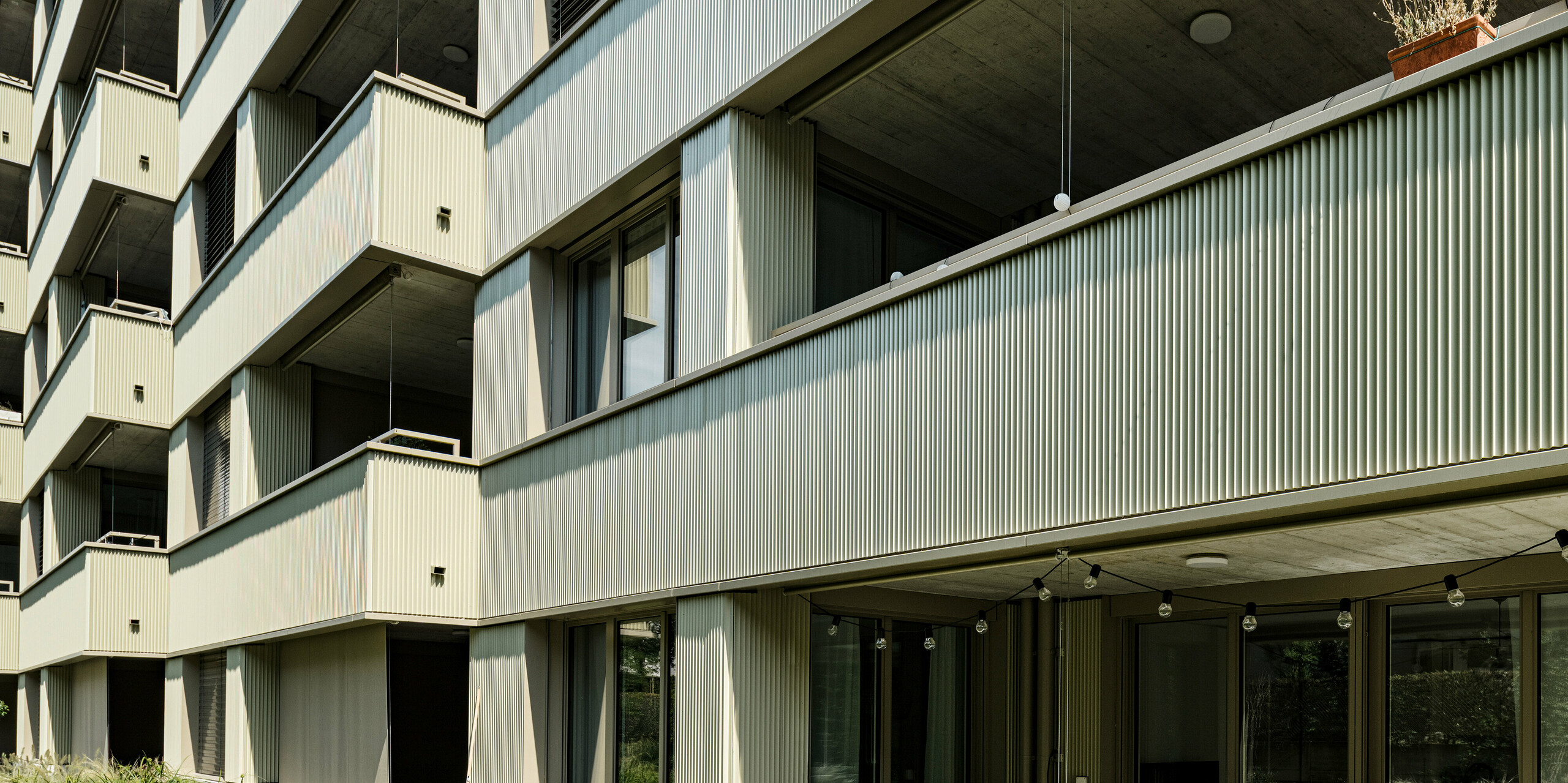 Sodobna stanovanjska stavba "Stetterhaus" v soseski Altstetten obdaja edinstvena fasada z zobčastimi profili PREFA v posebni biserno kovinski barvi.