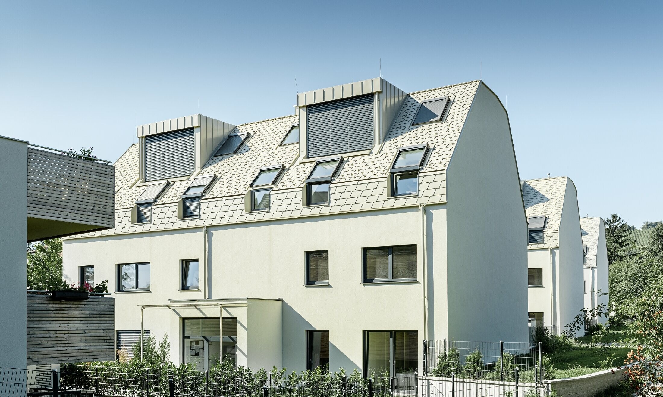 Nov stanovanjski kompleks z veliko aluminijasto strešno površino in strešnimi okni