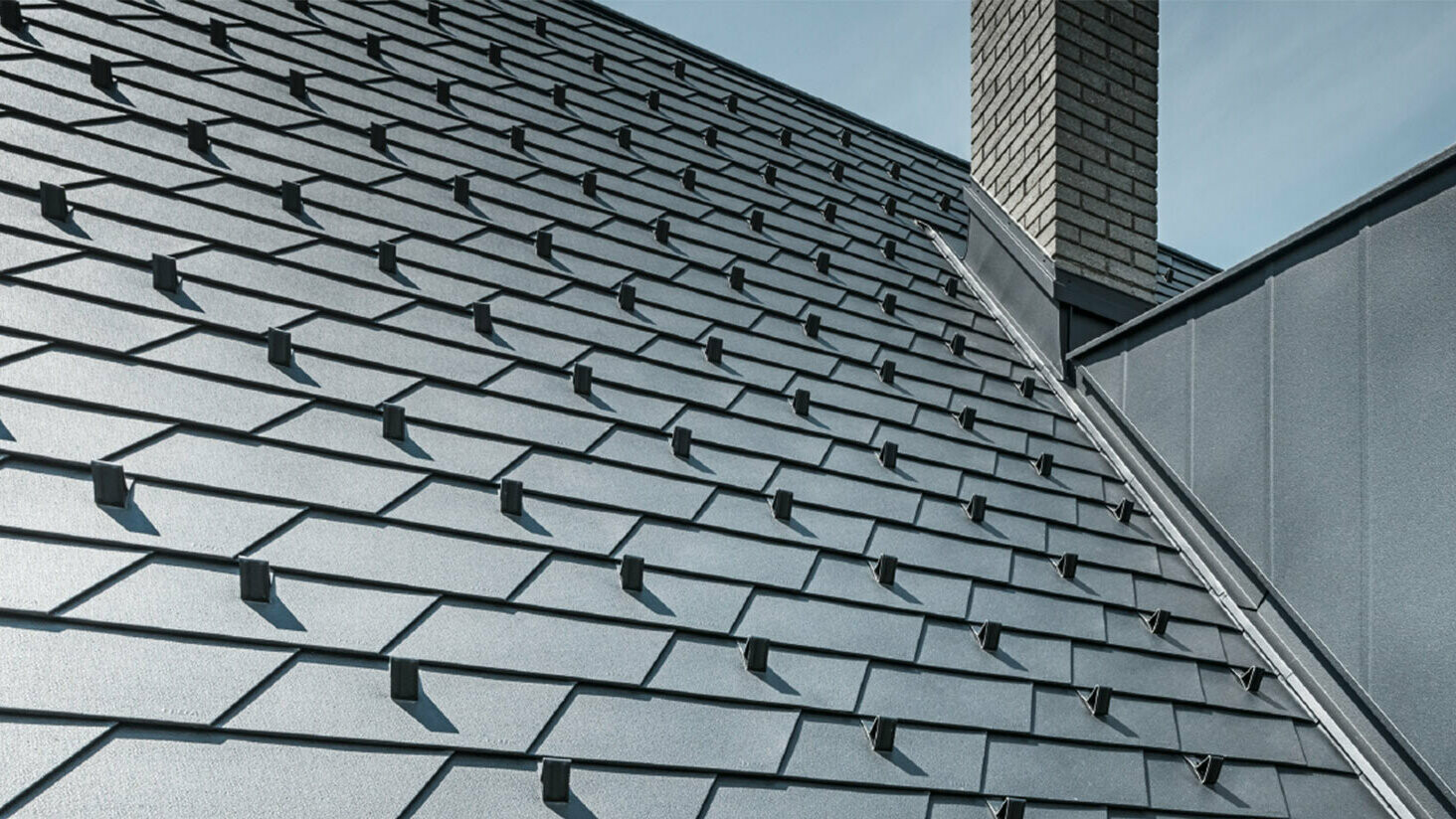 Prenovljena streha s strešnimi skodlami PREFA v izvedbi P.10 črna, vključno s snegolovom, frčada je prekrita z aluminijem PREFA