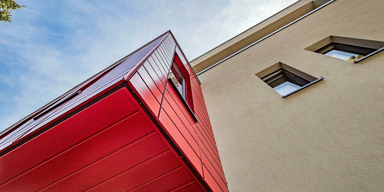 Erker mit linierten PREFA Sidings in rubinrot an einem modernen Einfamilienhaus in Wernigerode, hier ist die Untersicht des auskragenden Zubaus fotografiert.